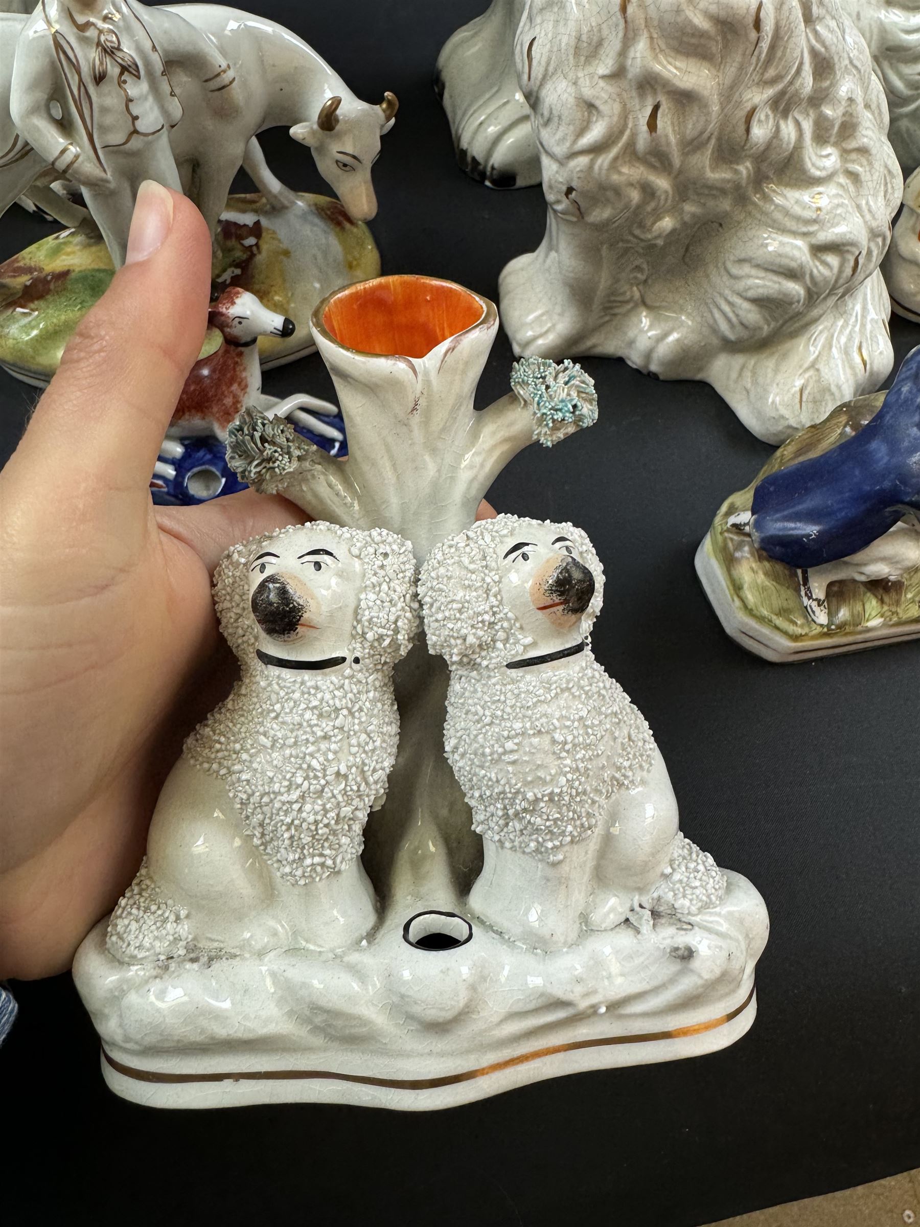 Staffordshire and Staffordshire style figures, to include a chained hound upon a blue oval base in the manner of Samuel Alcock, two pairs of seated Spaniels, a pair modelled as male figure and milk maid with cows, pair of recumbent Greyhounds, etc.