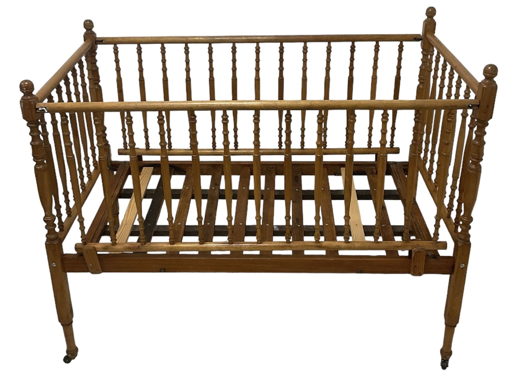 Victorian beech and pitch pine crib, turned spindle gallery supports, raised on square tapering supports with castors