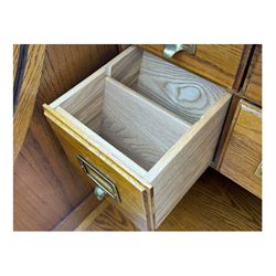 Early 20th century oak tambour roll-top desk, the top with fitted interior including drawers, pigeonholes and compartments, the twin pedestals fitted with four drawers with carved handles, supported by plinth base 