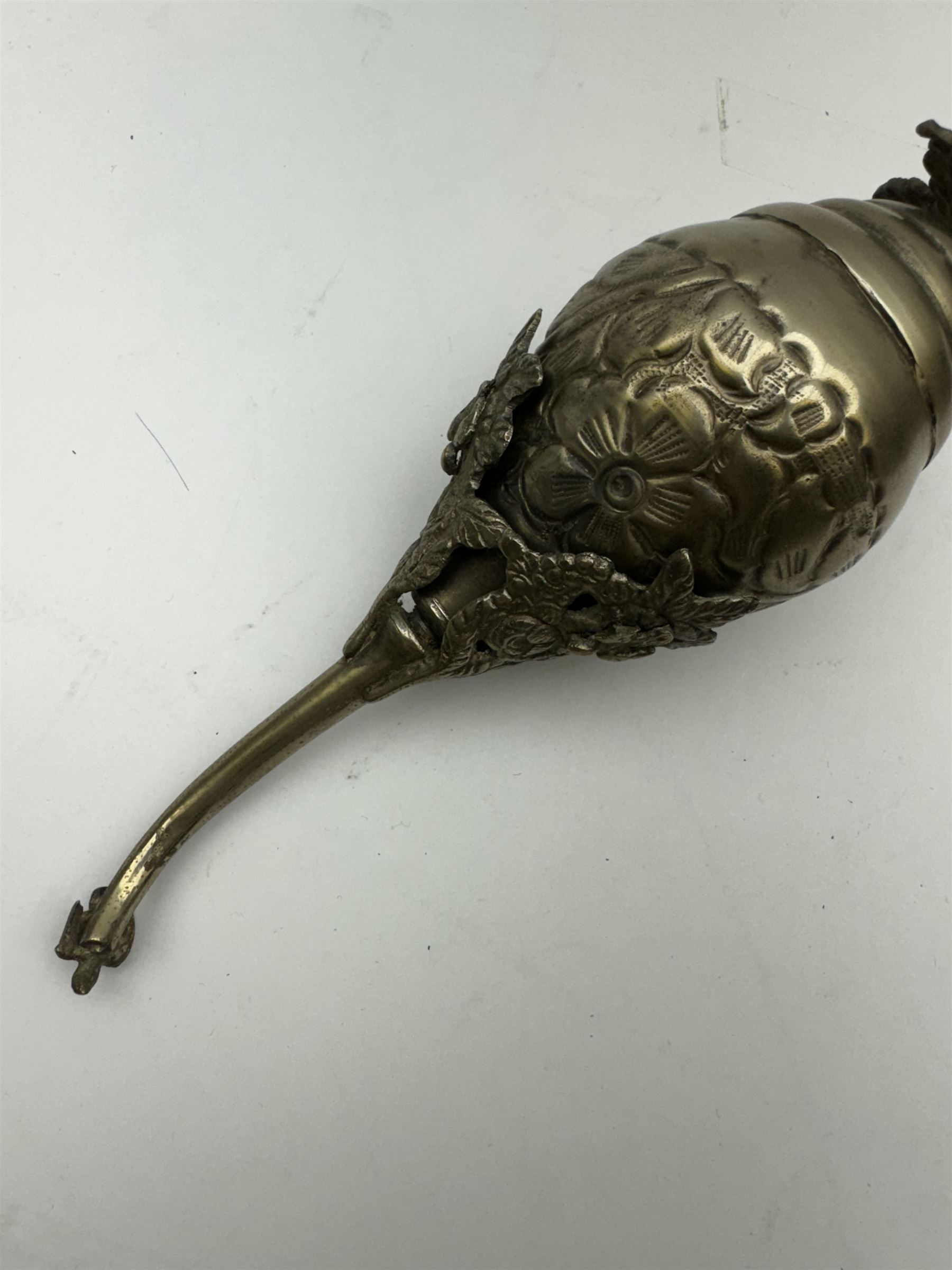 Egyptian white metal rosewater sprinkler, the pear shaped body embossed with flowers, the screw top with applied rose and bird decoration, upon foliate base, H20cm