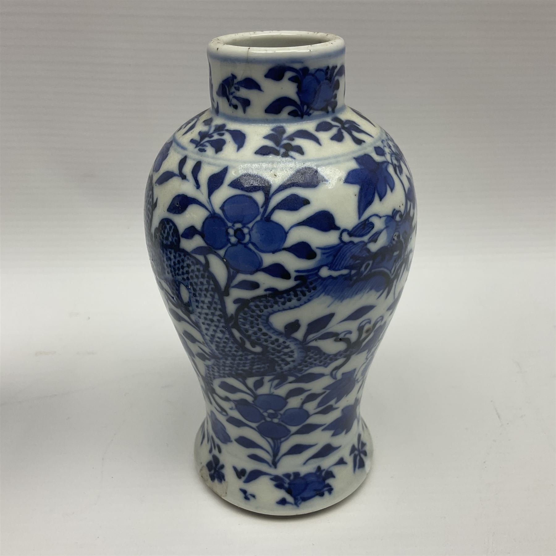 Pair of late 19th/early 20th century Chinese blue and white vases, each of baluster form, painted with dragons amidst flowers, each with Kangxi character marks beneath, H14cm 