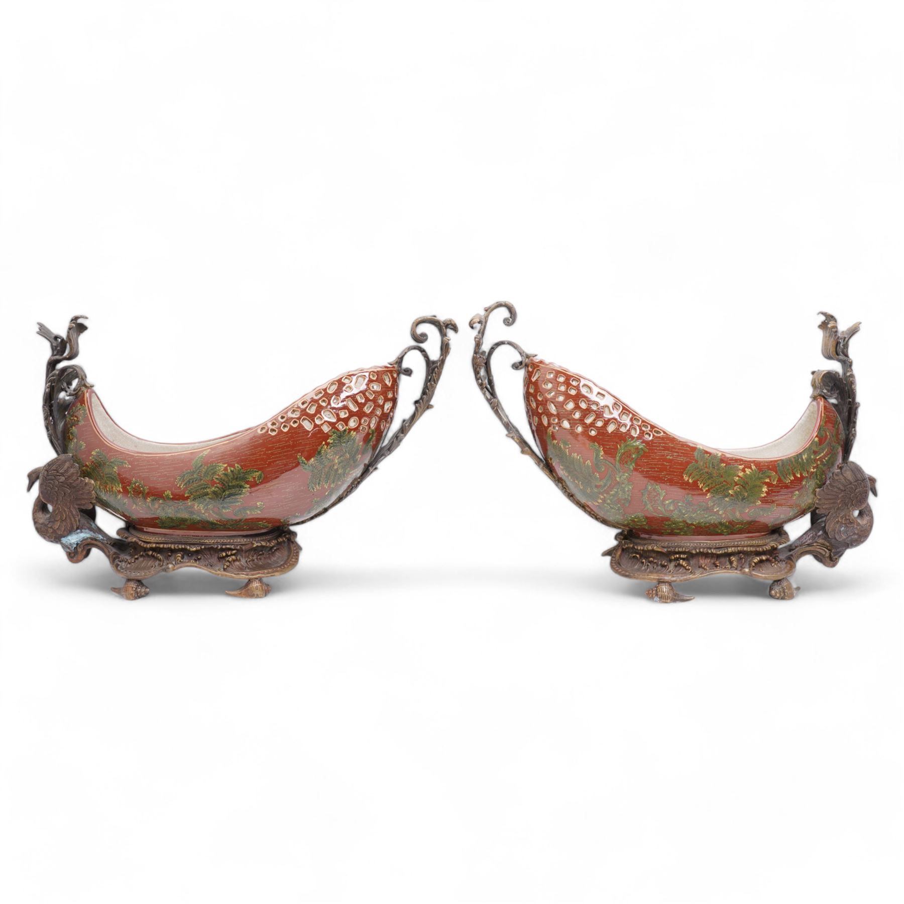 Pair of Continental ceramic and patinated metal table centre pieces, possibly by Castilian, each of boat form with pierced and polychrome decoration, with swan and shell moulded supports, H31cm x L46cm