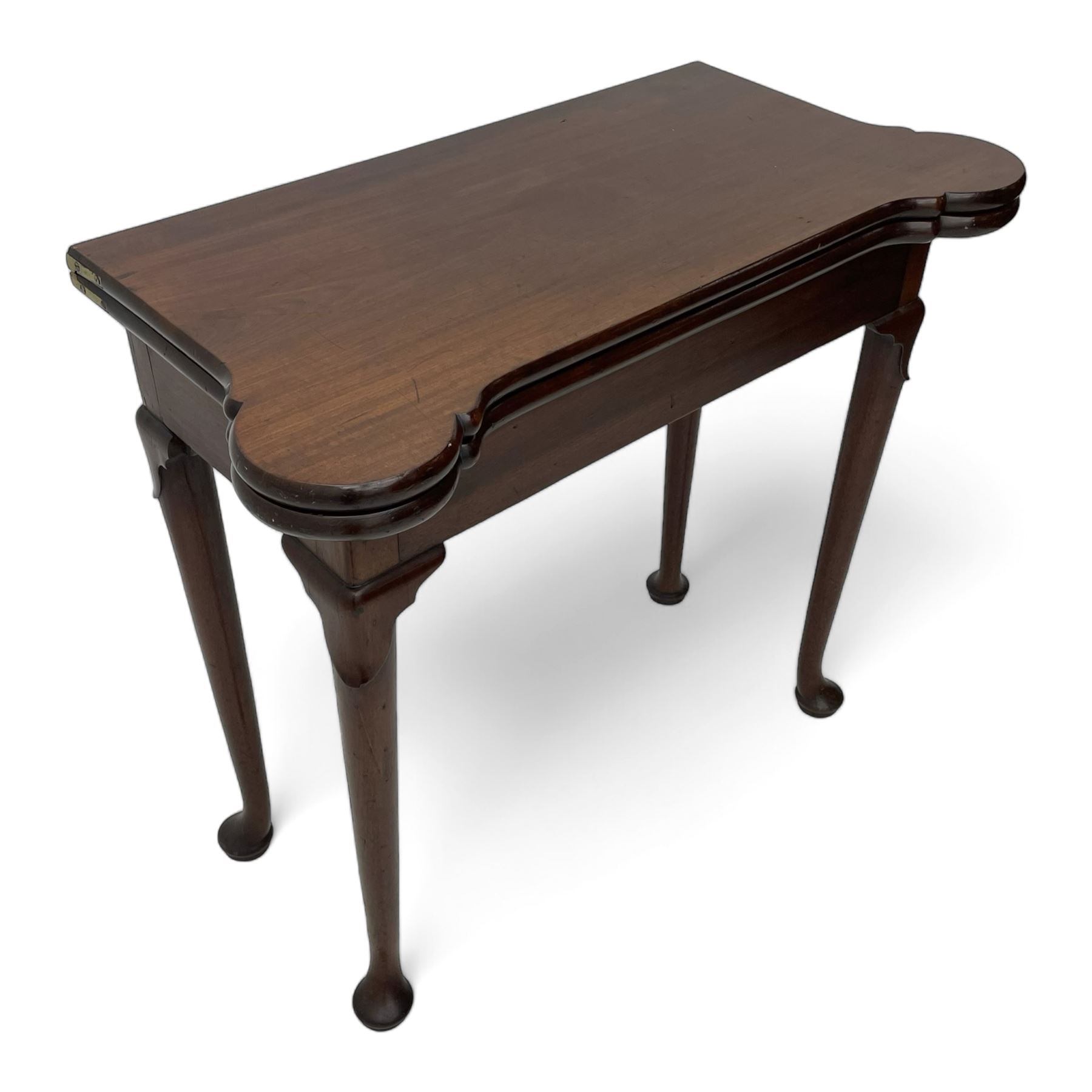 George III mahogany games table, the rectangular fold-over top with extending stepped rounded corners, opening to reveal baize lined interior with sunken counter wells, concertina action base, on lappet cabriole supports