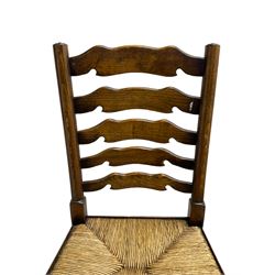 Matched set of eight (7+1) oak ladder back dining chairs, waved ladder back over rush seats, on turned supports joined by turned stretchers