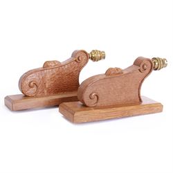 'Mouseman' pair of carved oak wall lights or sconces, scrolled decoration on chamfered rectangular mount, carved with mouse signature, with fittings and shades, by Robert Thompson of Kilburn