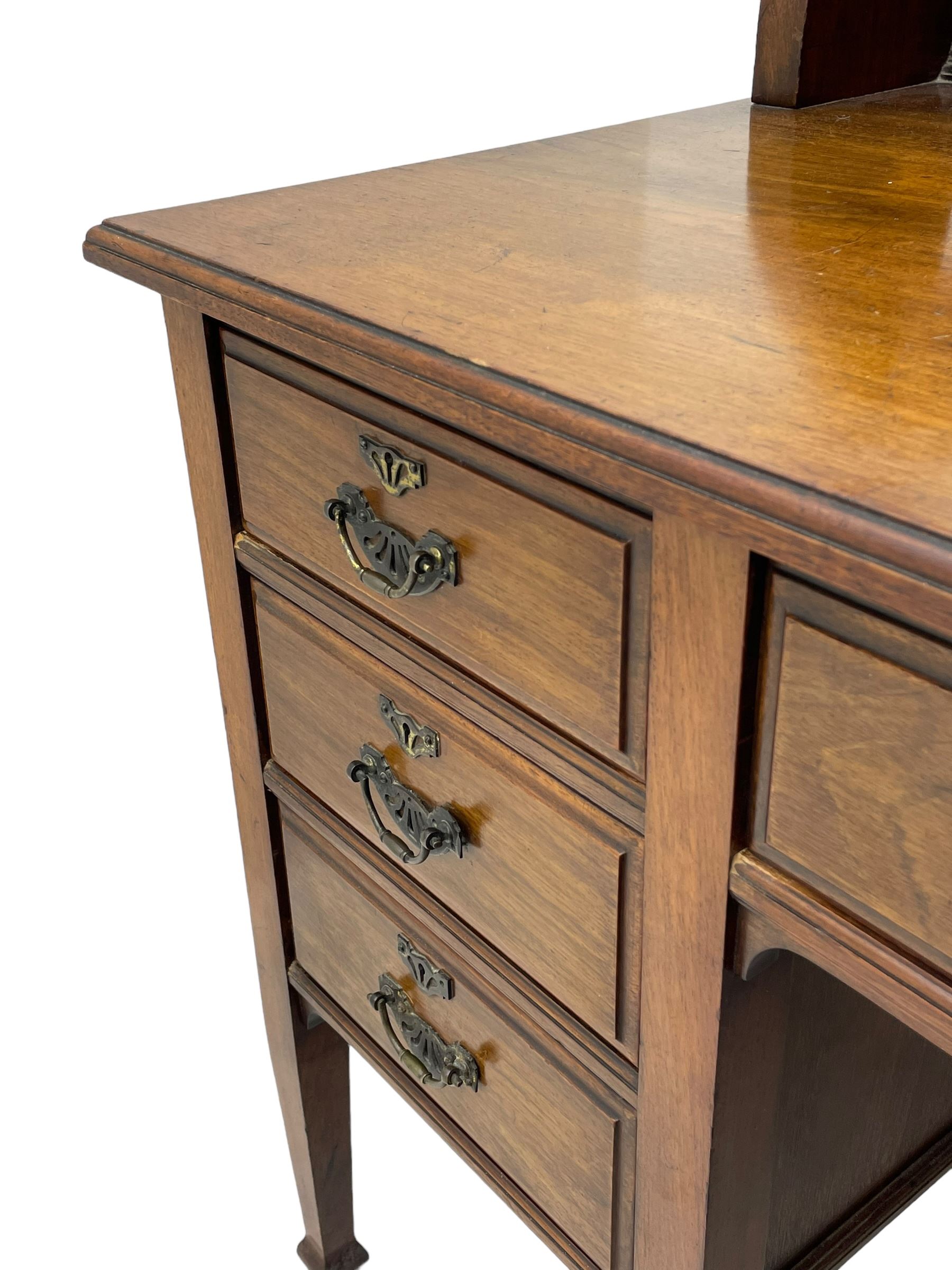 Late 19th century walnut dressing table, wide rectangular bevelled swing mirror in moulded frame, shaped horns carved with scrolls, moulded rectangular top over seven drawers, on square tapering supports with spade feet 