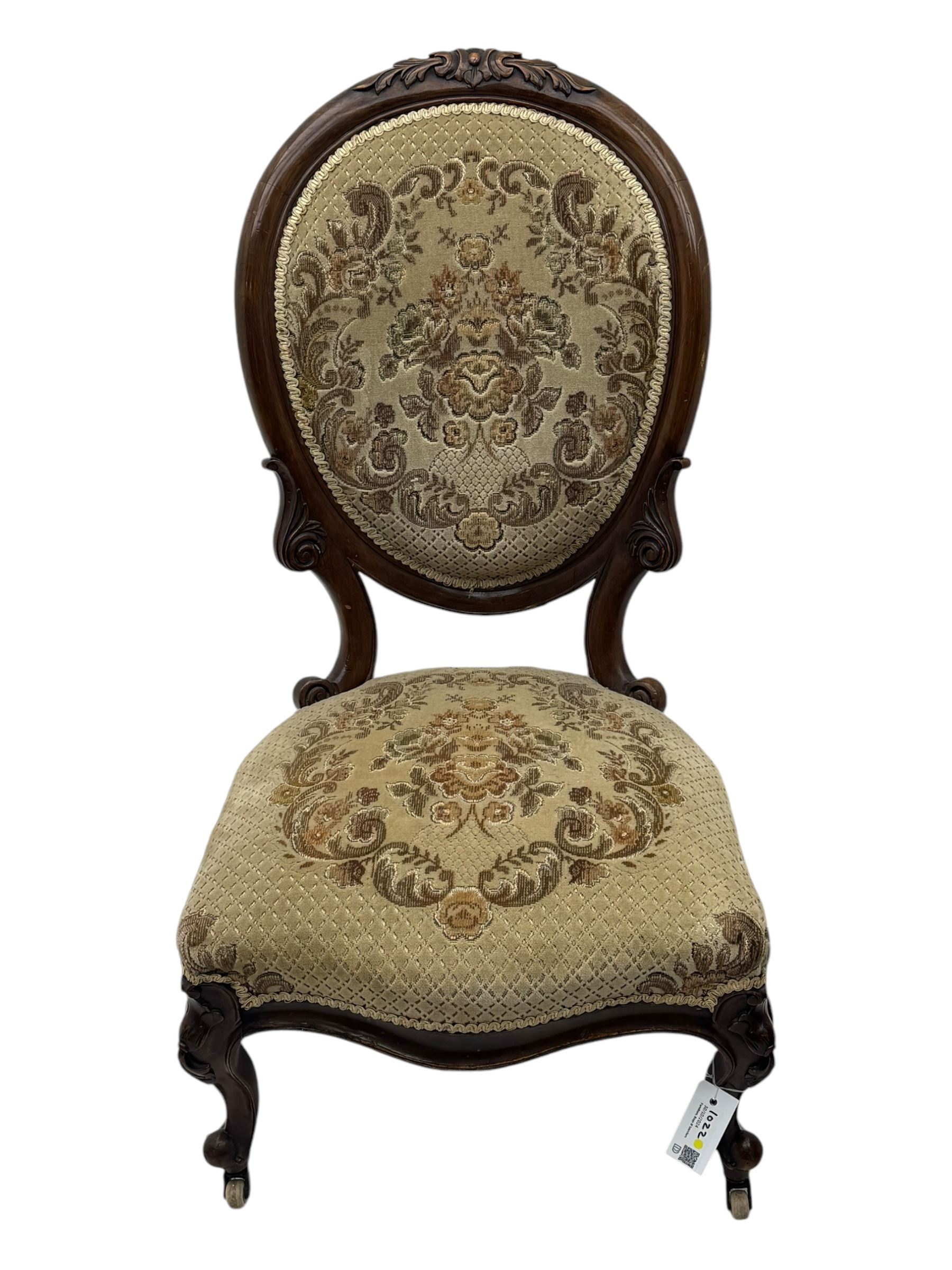 Pair of Victorian walnut lady's and gentleman's drawing room chairs, arched cresting rail carved with cartouche and extending foliage, upholstered in floral pattern fabric, on foliate carved cabriole feet