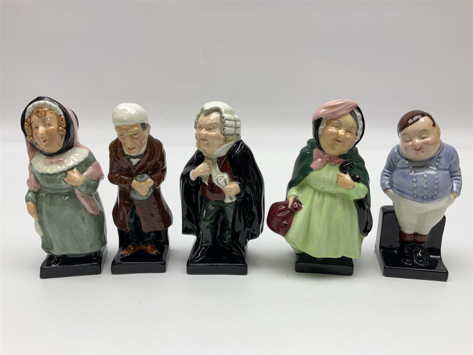 Twenty four Royal Doulton figures of characters from the works of Charles Dickens, to include Sam Weller, Pecksniff, Oliver Twist, Sairey Gamp, Artful dodger etc