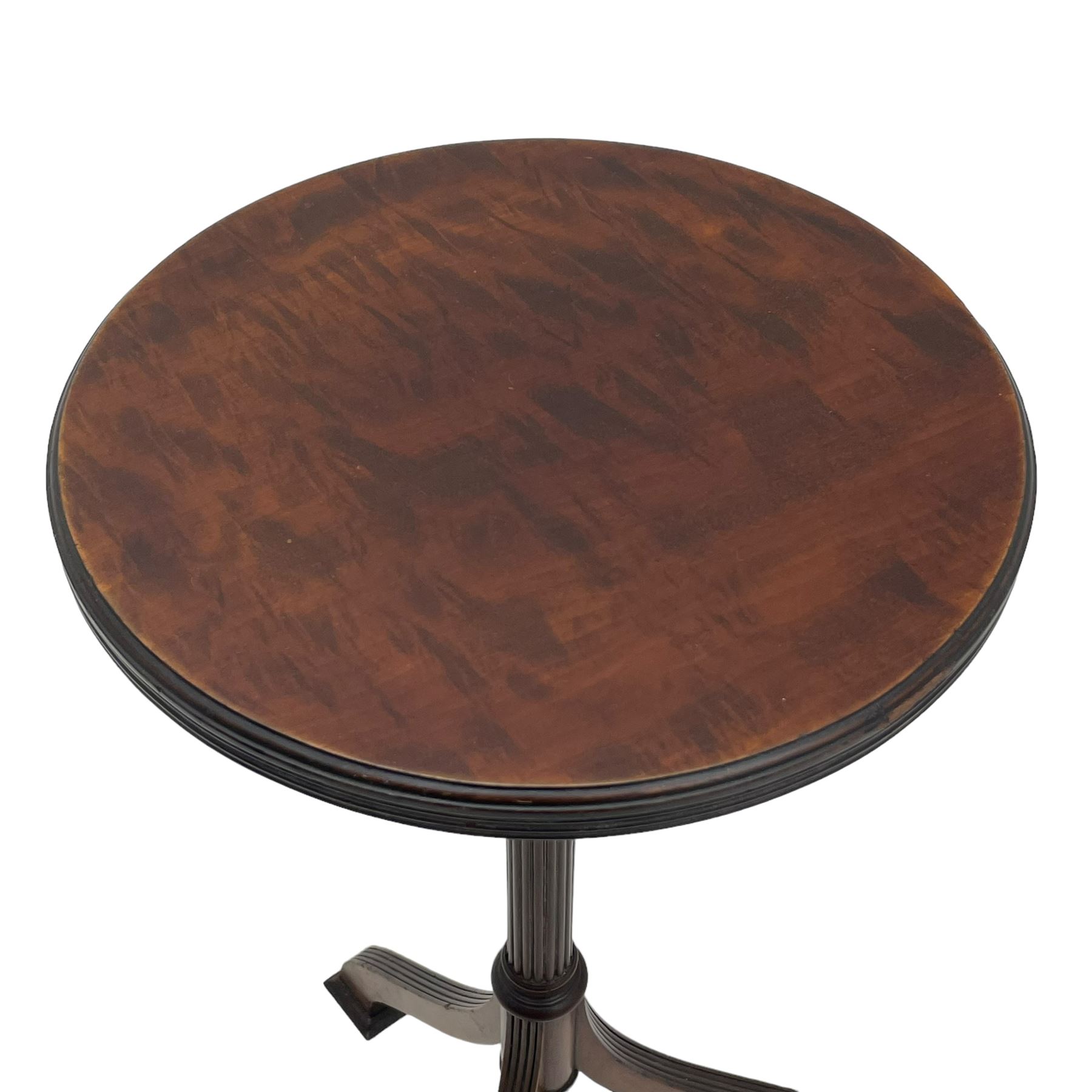 Early 20th century mahogany wine table, figured circular top with reeded edge, on turned and reed moulded stem, three reeded tapered supports on rectangular moulded pad feet 