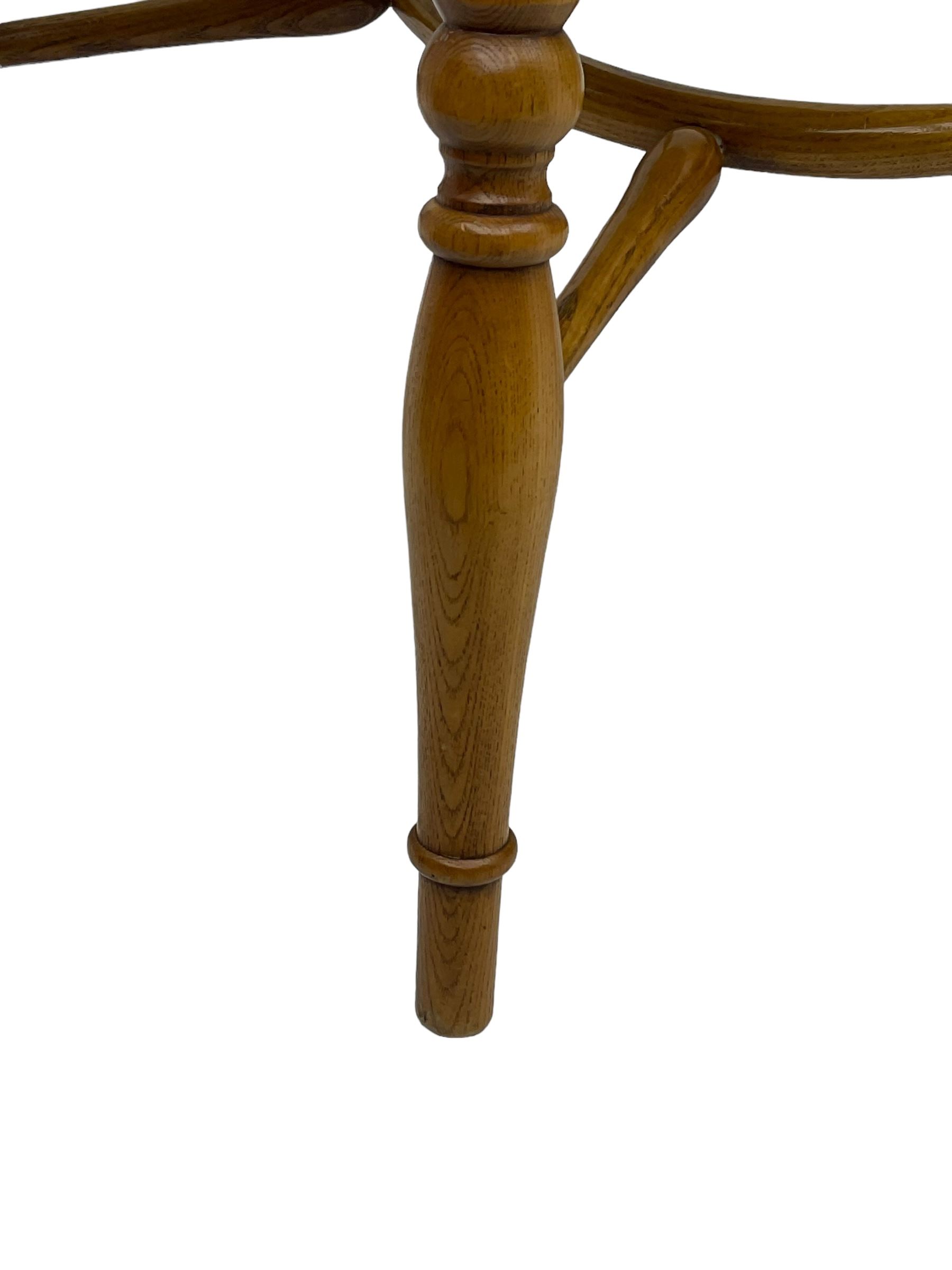 Set of four elm Windsor dining chairs, hoop and stick back with shaped wheel splat, dished seat on turned supports united by crinoline stretcher 