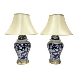 Pair of table lamps, decorated with gold bands and decoration of white blossom flowers on ...