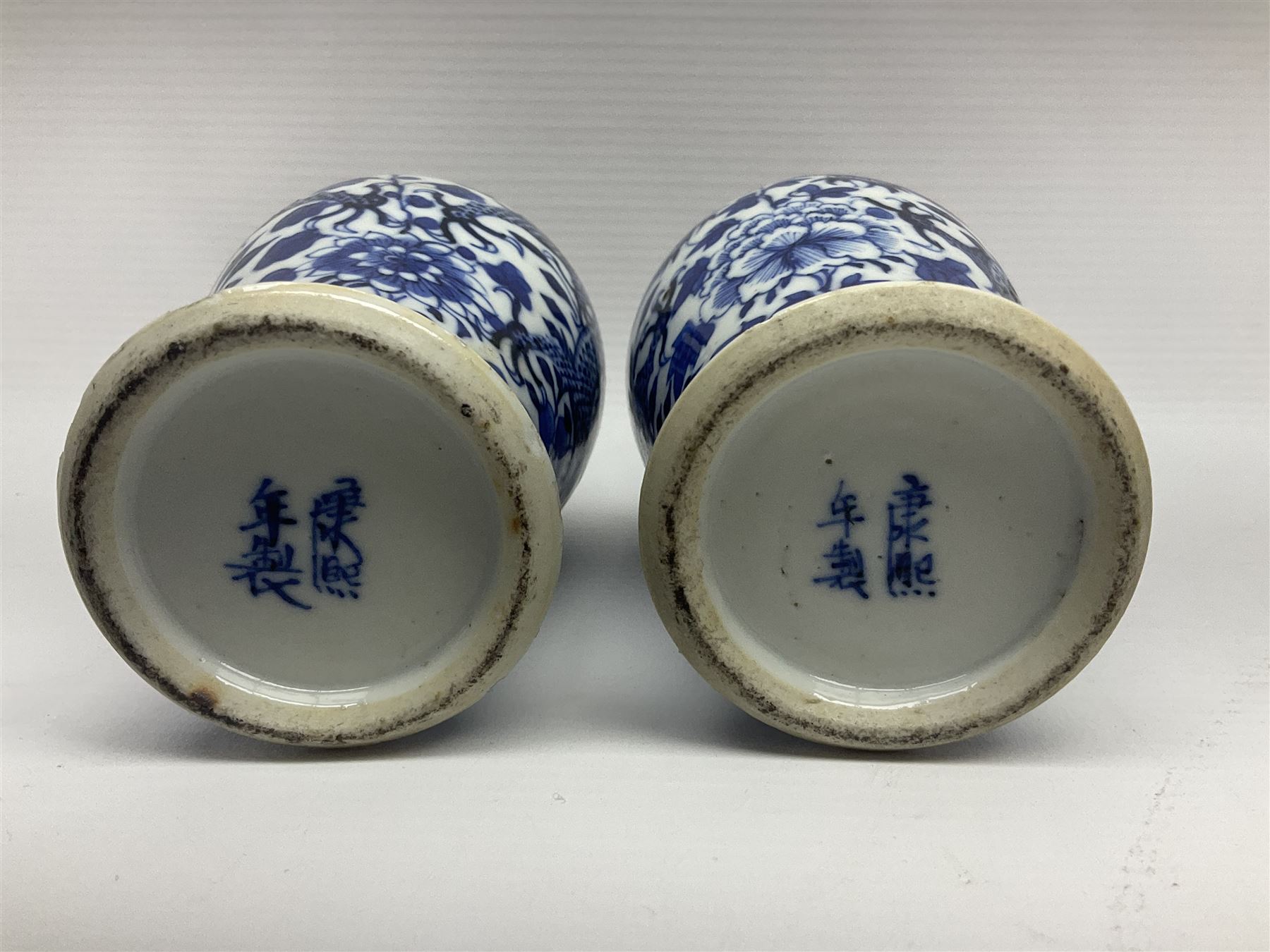 Pair of late 19th/early 20th century Chinese blue and white vases, each of baluster form, painted with dragons amidst flowers, each with Kangxi character marks beneath, H14cm 