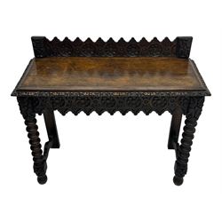 Victorian Gothic revival style carved oak console table, rectangular top with carved edge and raised back gallery, over deeply carved apron with floral and foliate motifs and central drawer, barley twist front supports and plain rear supports united by shaped stretchers, on front bun feet