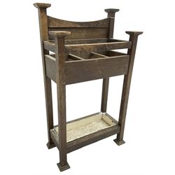 Early 20th century Arts & Crafts oak stick stand, panelled back over three divisions, fitted with metal drip tray, on square supports