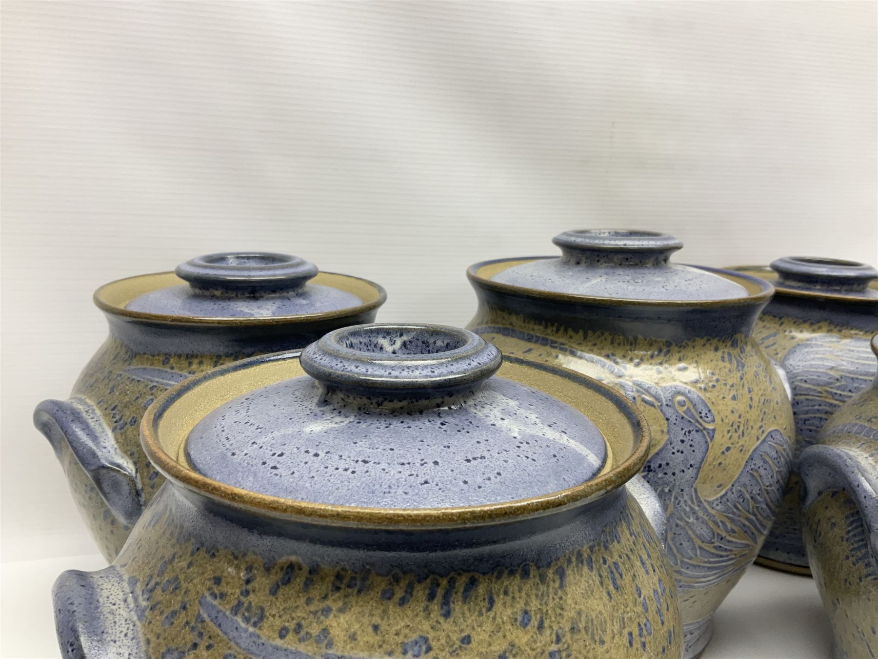 John Egerton (c1945-): set of five studio pottery stoneware twin handled jars with covers, decorated with blue birds upon a brown mottled ground, H20cm