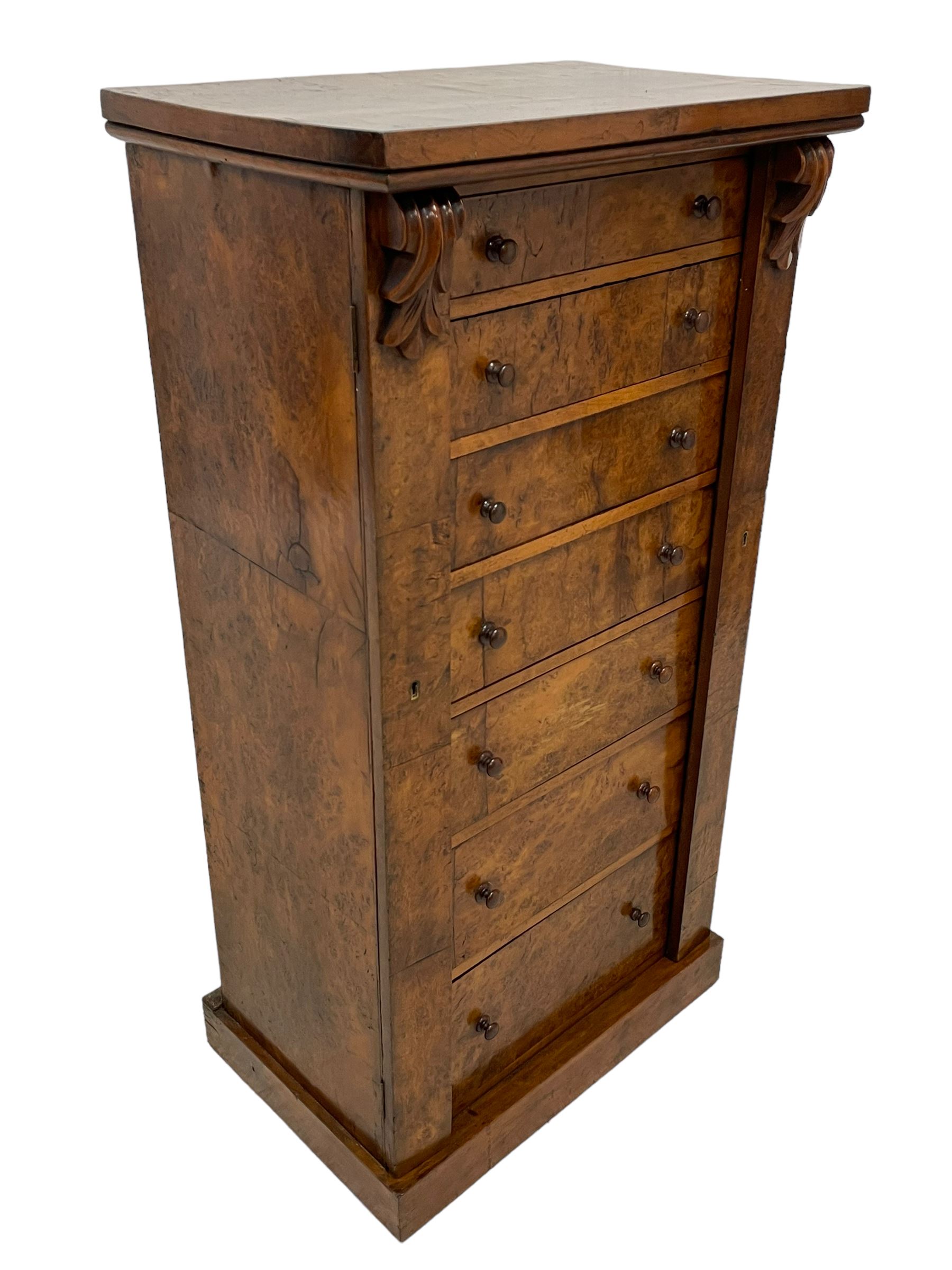 Victorian burr walnut Wellington chest, rectangular top with book-matched veneers, two hinged uprights with scrolled foliage carved brackets enclosing seven graduating drawers, on plinth base 