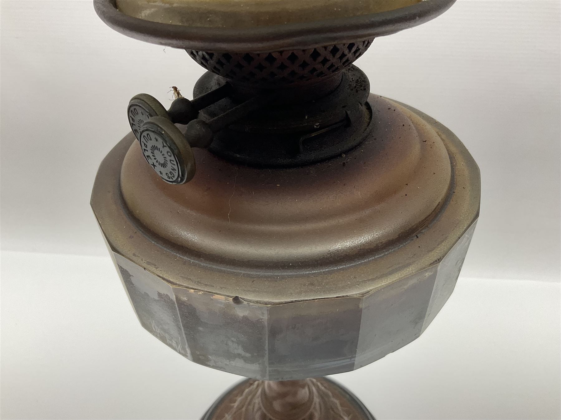 Victorian oil lamp, the faceted reservoir upon embossed copper stem and stepped circular ceramic base, with etched floral glass shade