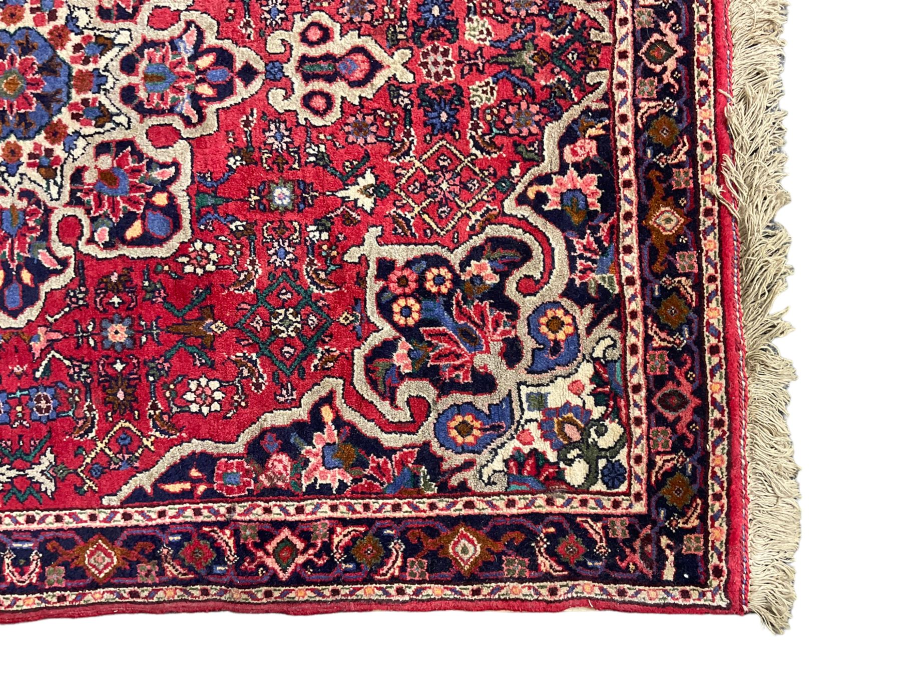 Persian Hamadan crimson ground rug, central floral pole medallion with matching spandrels, the guarded indigo border with interlaced palmettes