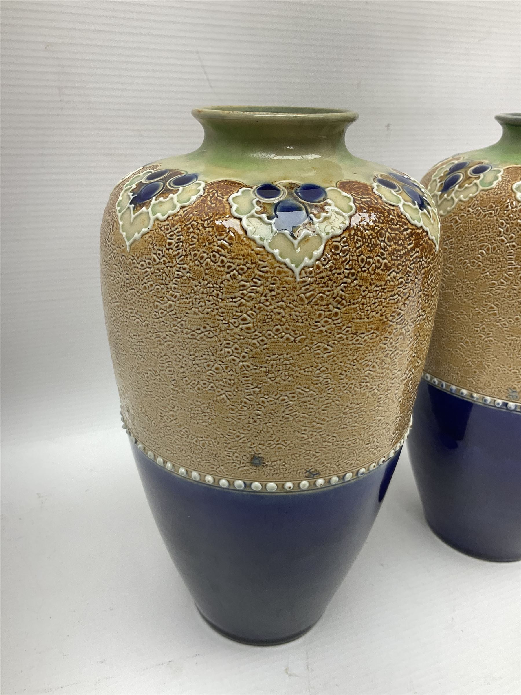 Pair of Royal Doulton Lambeth stoneware baluster vases, decorated in light relief with foliage, impressed mark beneath, H23cm