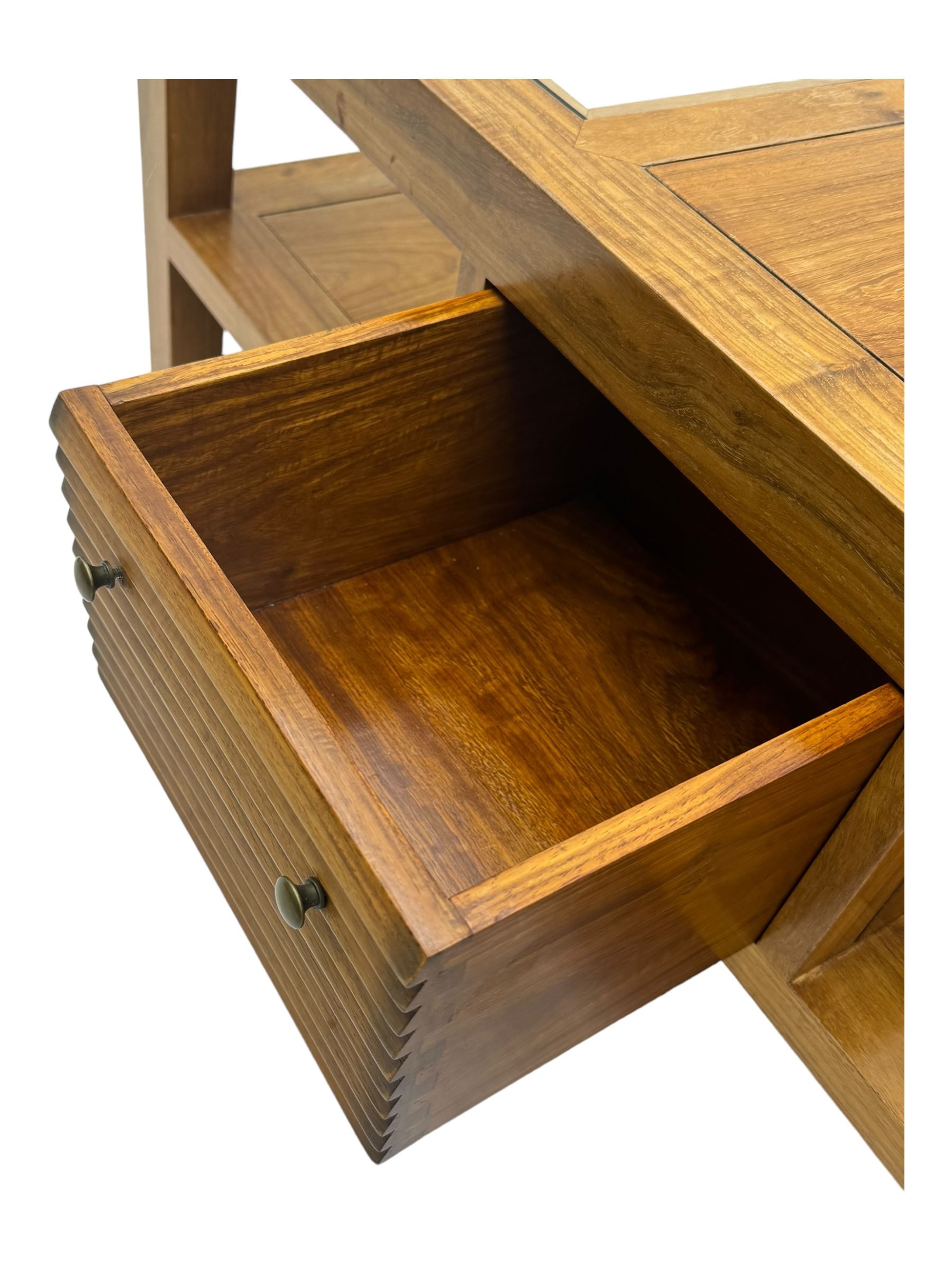 Starbay Tobago cherry wood coffee table, rectangular top with two inset glass panels, central drawer with louvred front and brass handles, flanked by open shelving, raised on square supports with metal corner brackets