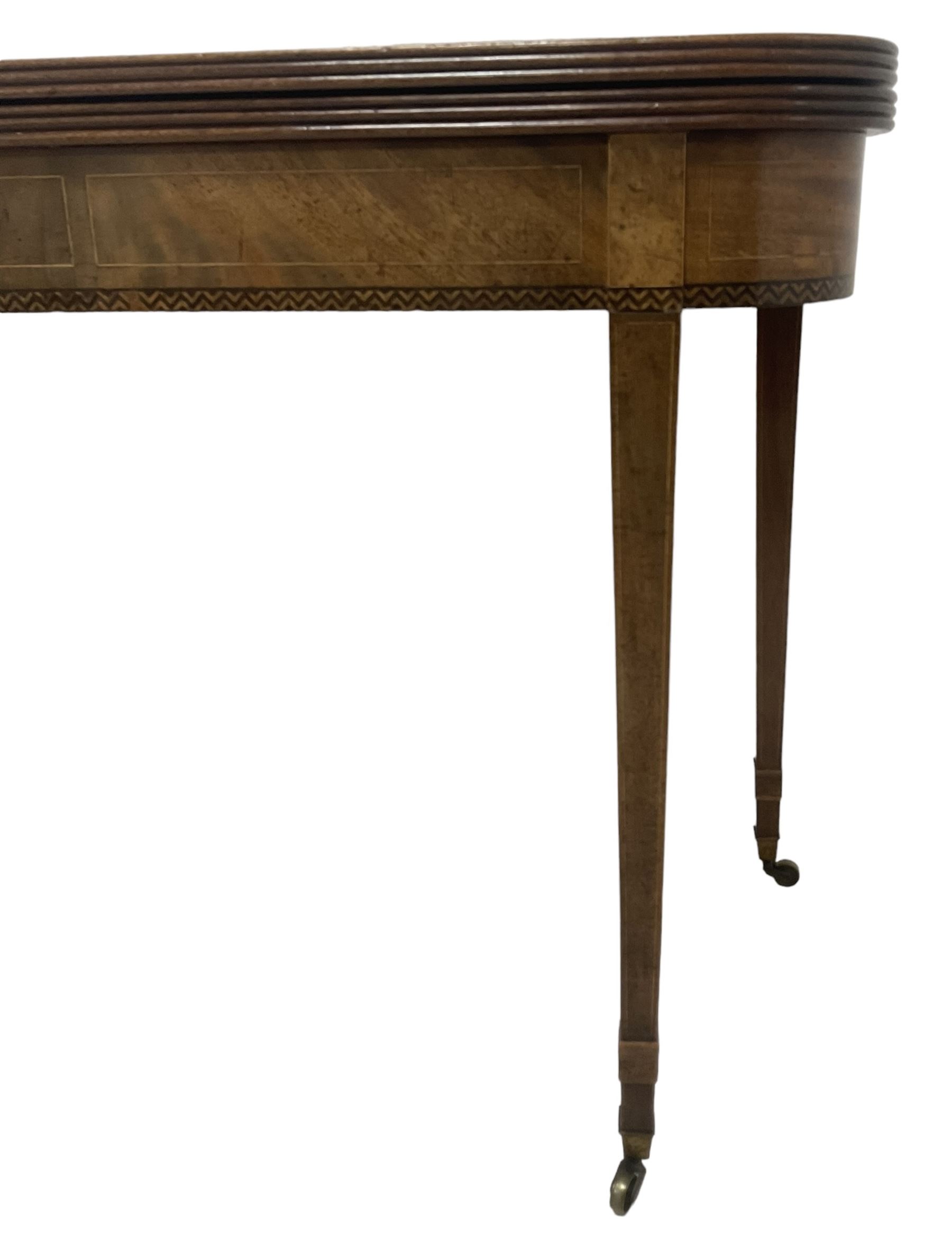 19th century mahogany tea table, fold-over top with reeded edge over inlaid frieze, on double gate-leg action square tapering supports, with brass castors