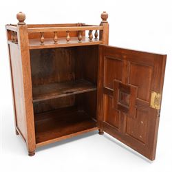 Late 19th century Aesthetic Movement walnut cupboard, raised and pierced spindle gallery surmounted by ring-turned finials, over a panelled door decorated with central foliate carved panel and surrounded by plain geometric shaped panels, applied with brass fittings and loop handle, on turned feet