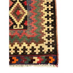 Northeast Persian Sumak Kilim red ground rug, the field decorated with rows of multicoloured diamond motifs featuring  geometric patterns, the border composed of alternating black and white stepped designs, enclosed by a narrow band with multicoloured geometric shapes