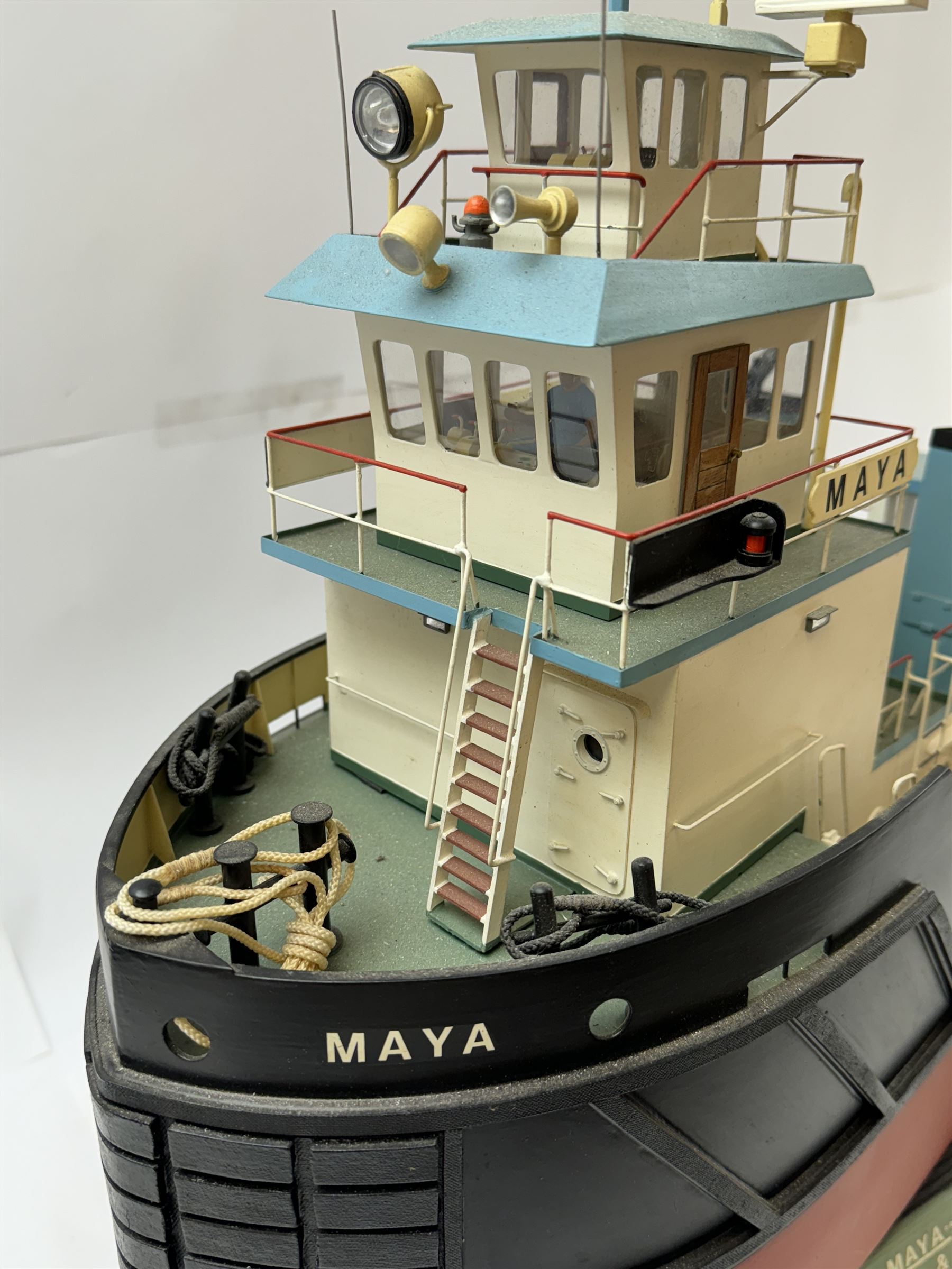 Modern model of American Coastal and River Tugboat 'Maya', in red, black and light blue finish, upon a green stand inscribed with name, H53cm, W52cm 