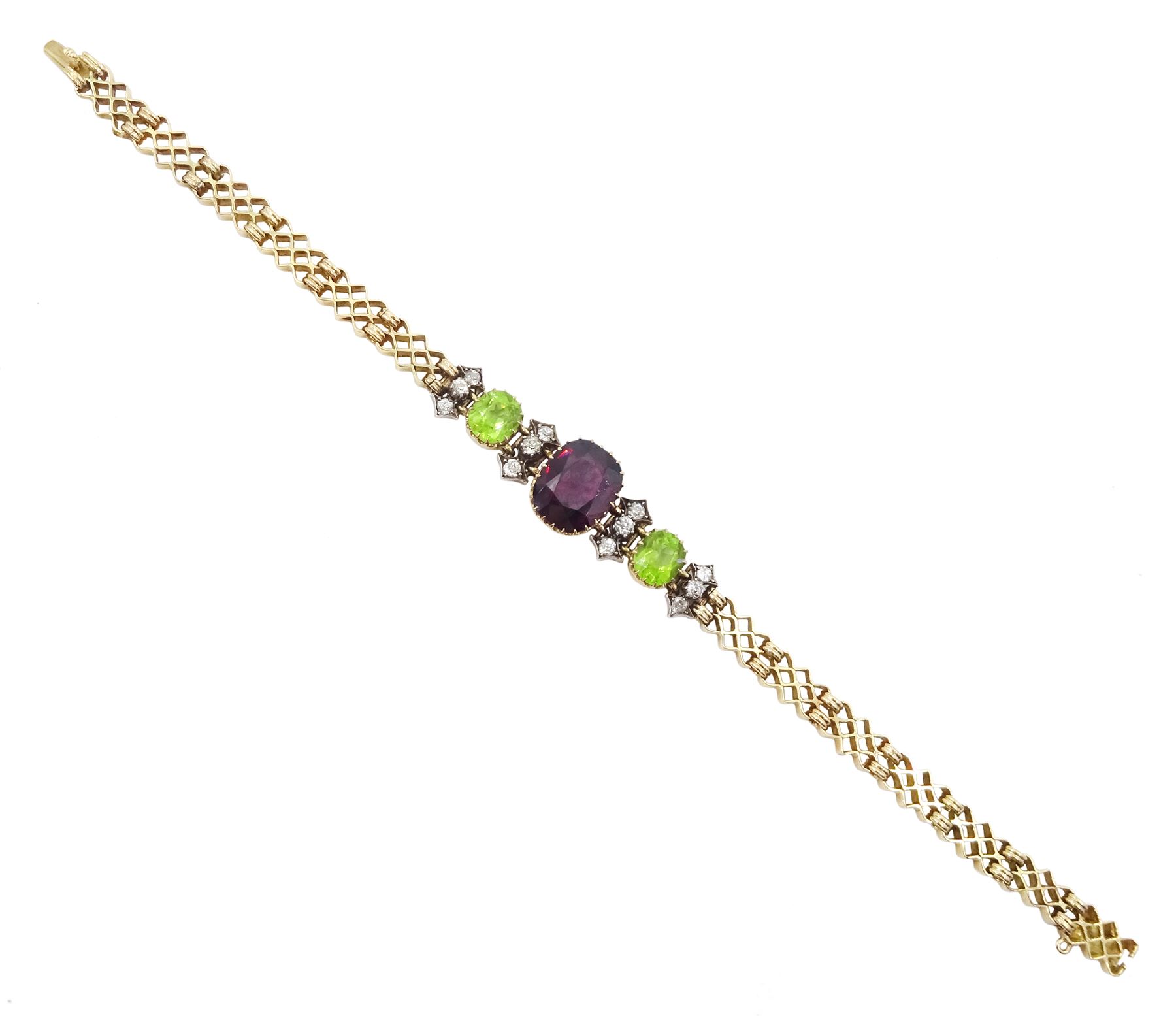 Early 20th century 15ct gold garnet, peridot and diamond, fancy link chain bracelet, the central cushion cut rhodolite garnet of approx 5.05 carat, with two cushion cut peridots set either side, spaced by three old cut diamonds, total diamond weight approx 0.35 carat, in fitted case by Garrard & Co