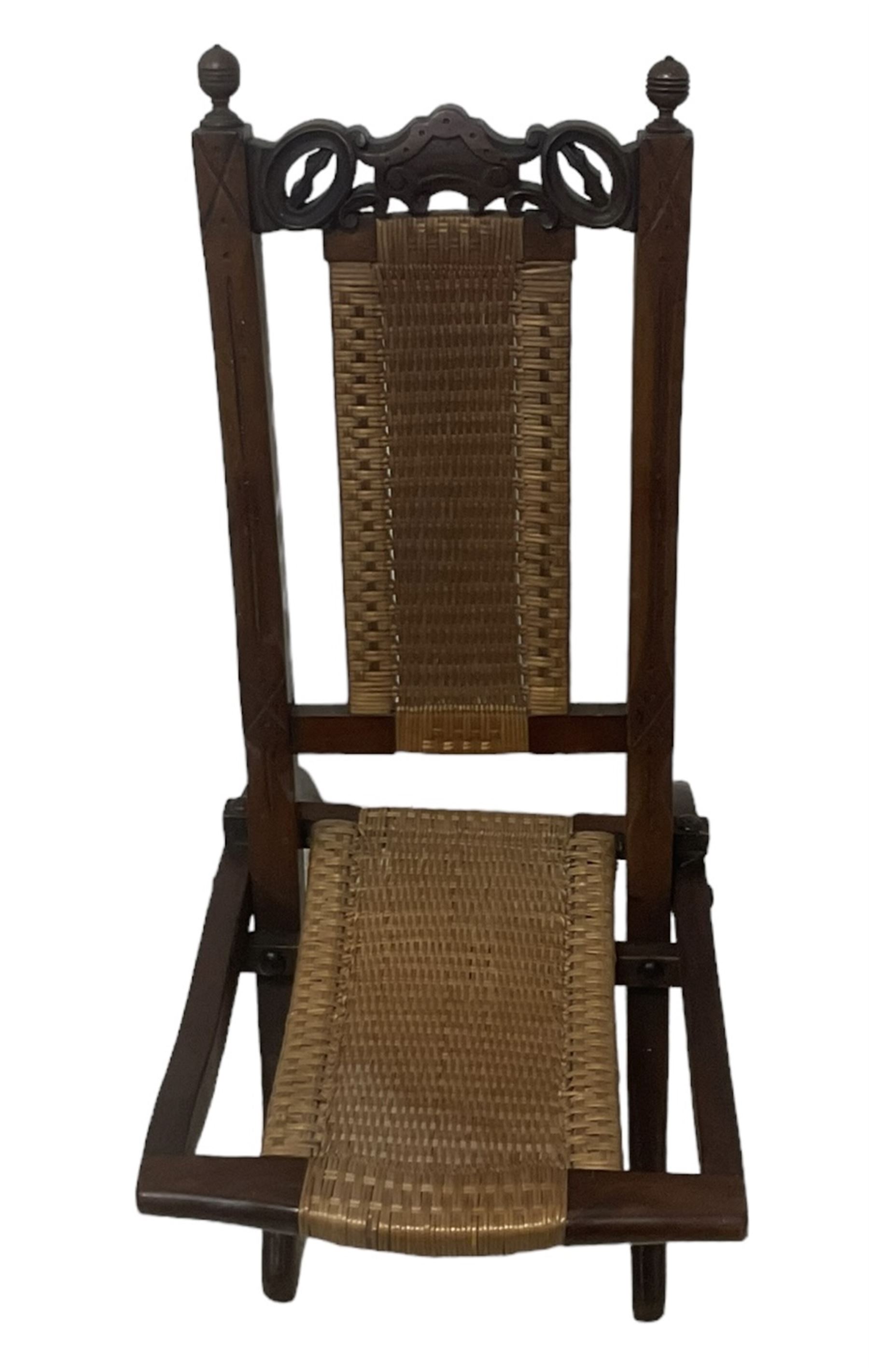 Victorian Aesthetic Movement mahogany framed folding campaign chair, pierced and carved cresting rail with carved and chamfered uprights, rattan back and seat