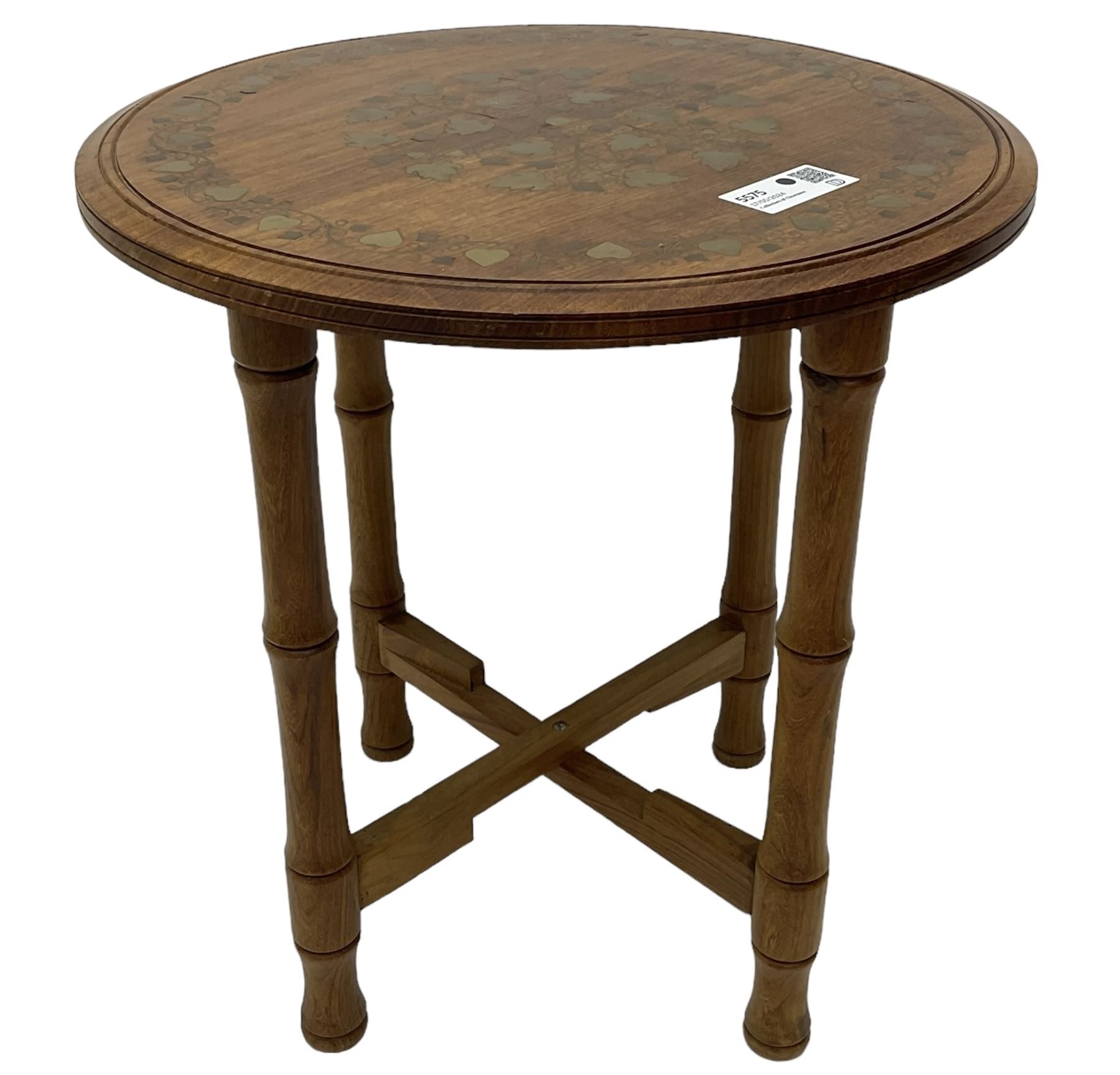 Small brass inlaid hardwood occasional table, the circular top inlaid with trailing foliate decoration, on turned folding base 