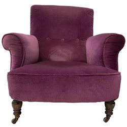 Late Victorian upholstered armchair, in deep purple velvet fabric, buttoned backrest, rolled arms, on splayed back and turned front supports with castors