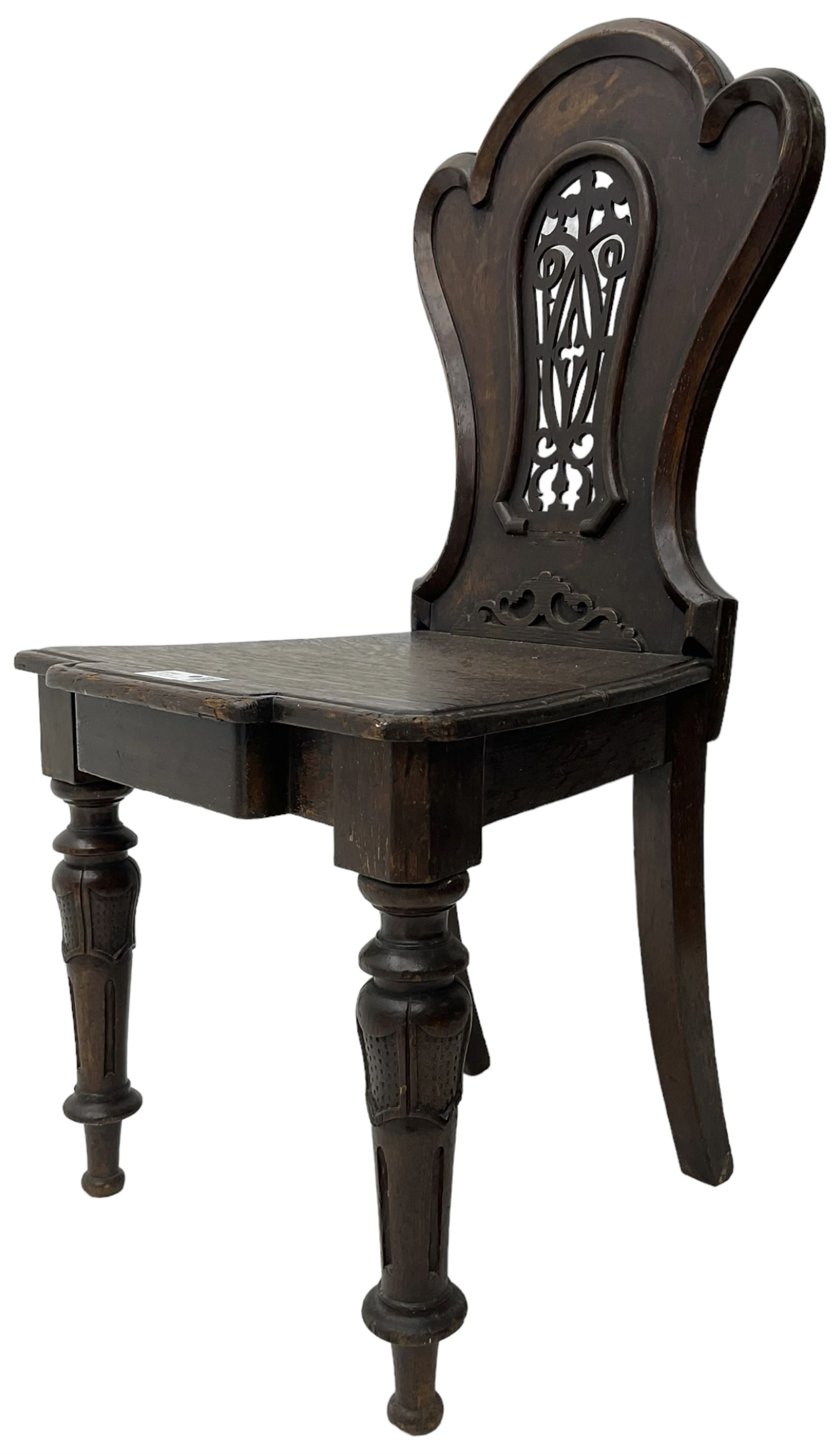 Victorian oak hall chair, the shaped back with fretwork splat, stepped moulded seat on turned lappet supports with fluting 