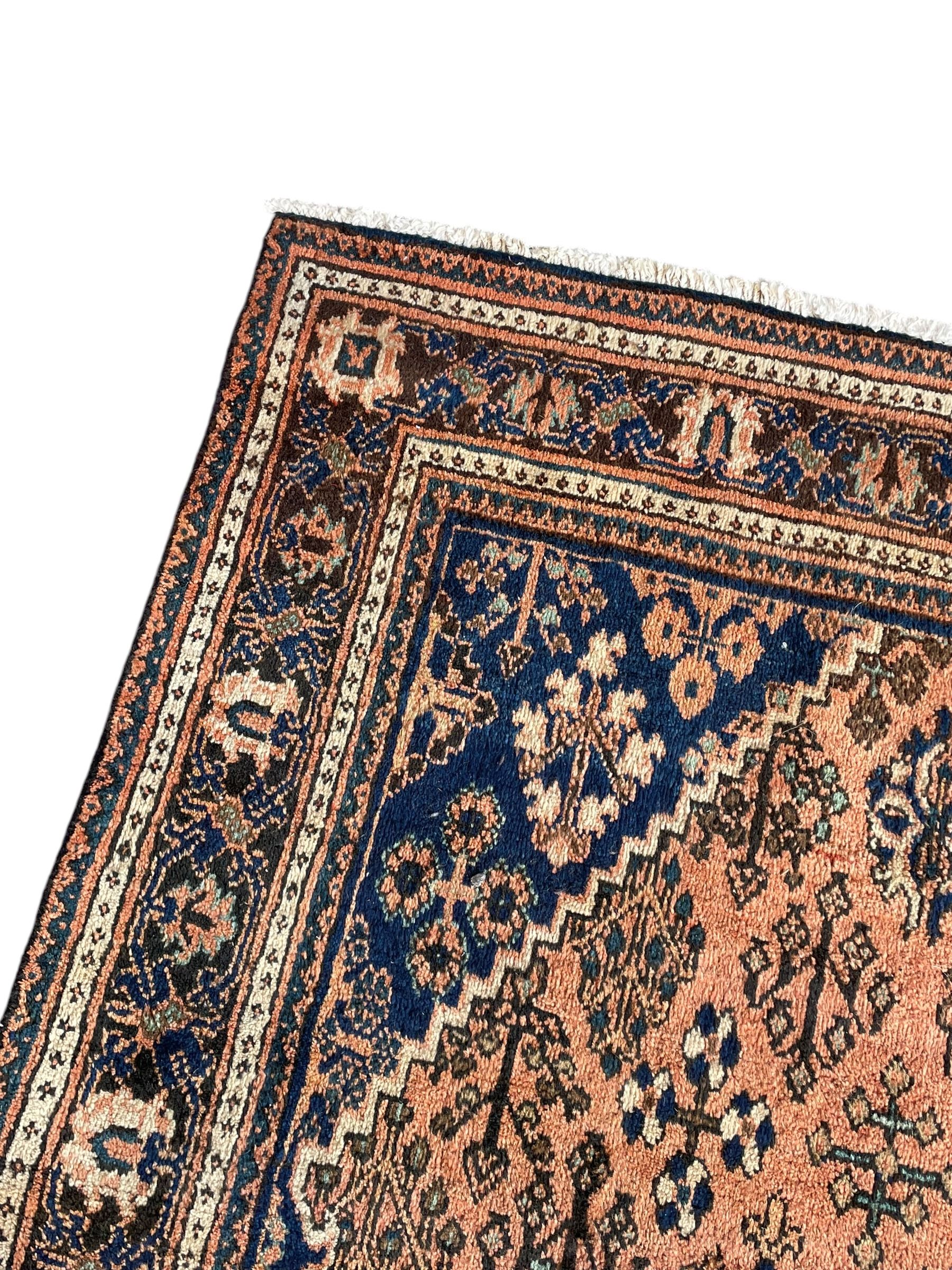 Persian Joshaghan peach and blue ground rug, central stepped lozenge medallion surrounded by bunches of floral motifs, repeating border decorated with stylised plant motifs, within multiple guard stripes