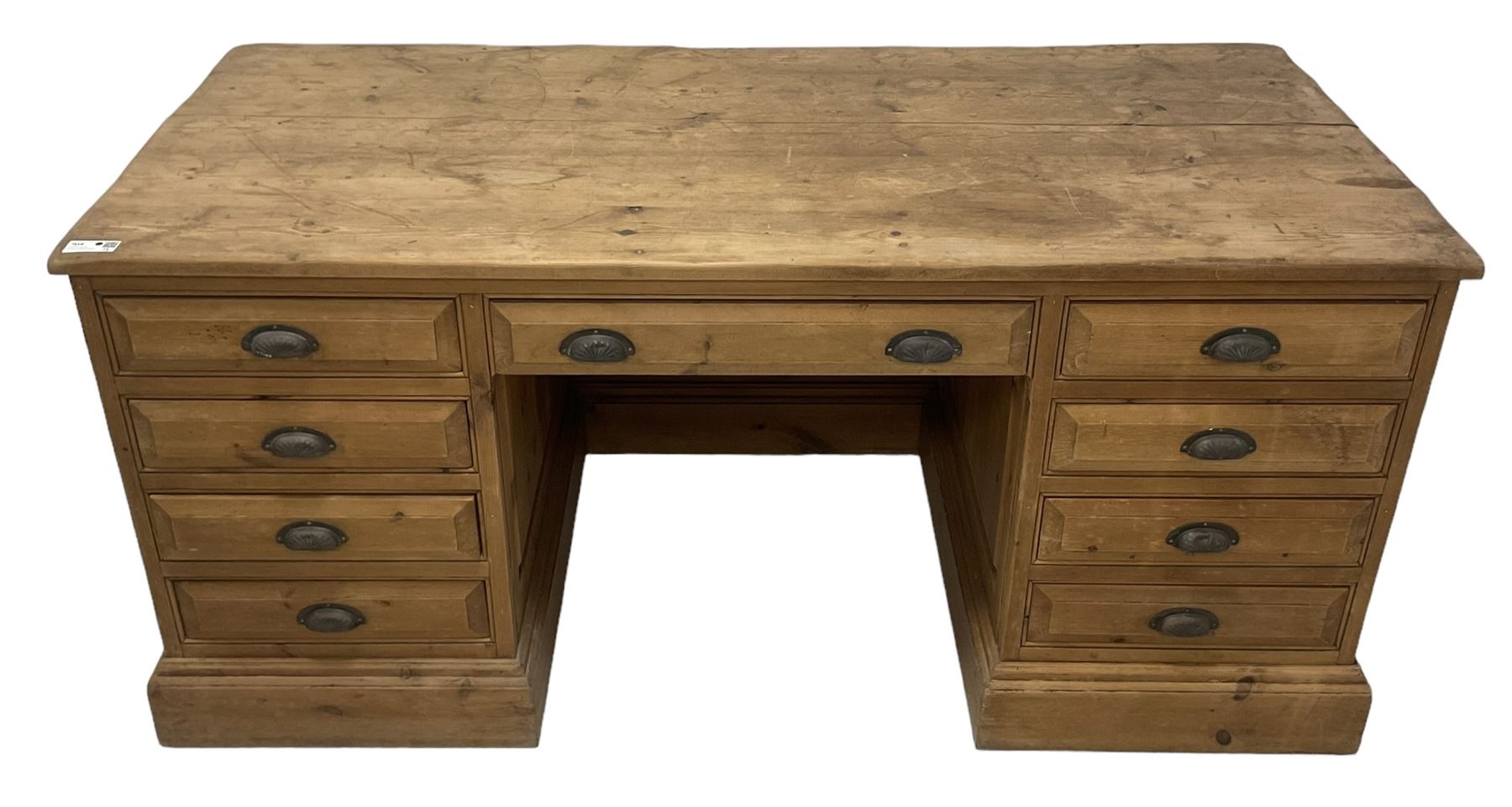 20th century waxed pine kneehole desk, rectangular top over nine drawers with cup handles, on moulded plinth base