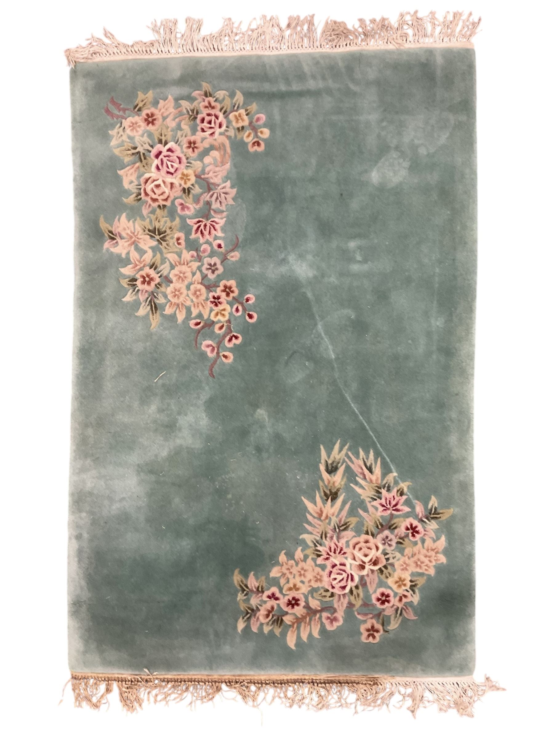 Chinese pale turquoise ground washed woolen rug, the plain field decorated with two large floral bouquet motifs with extending blossom and leafage