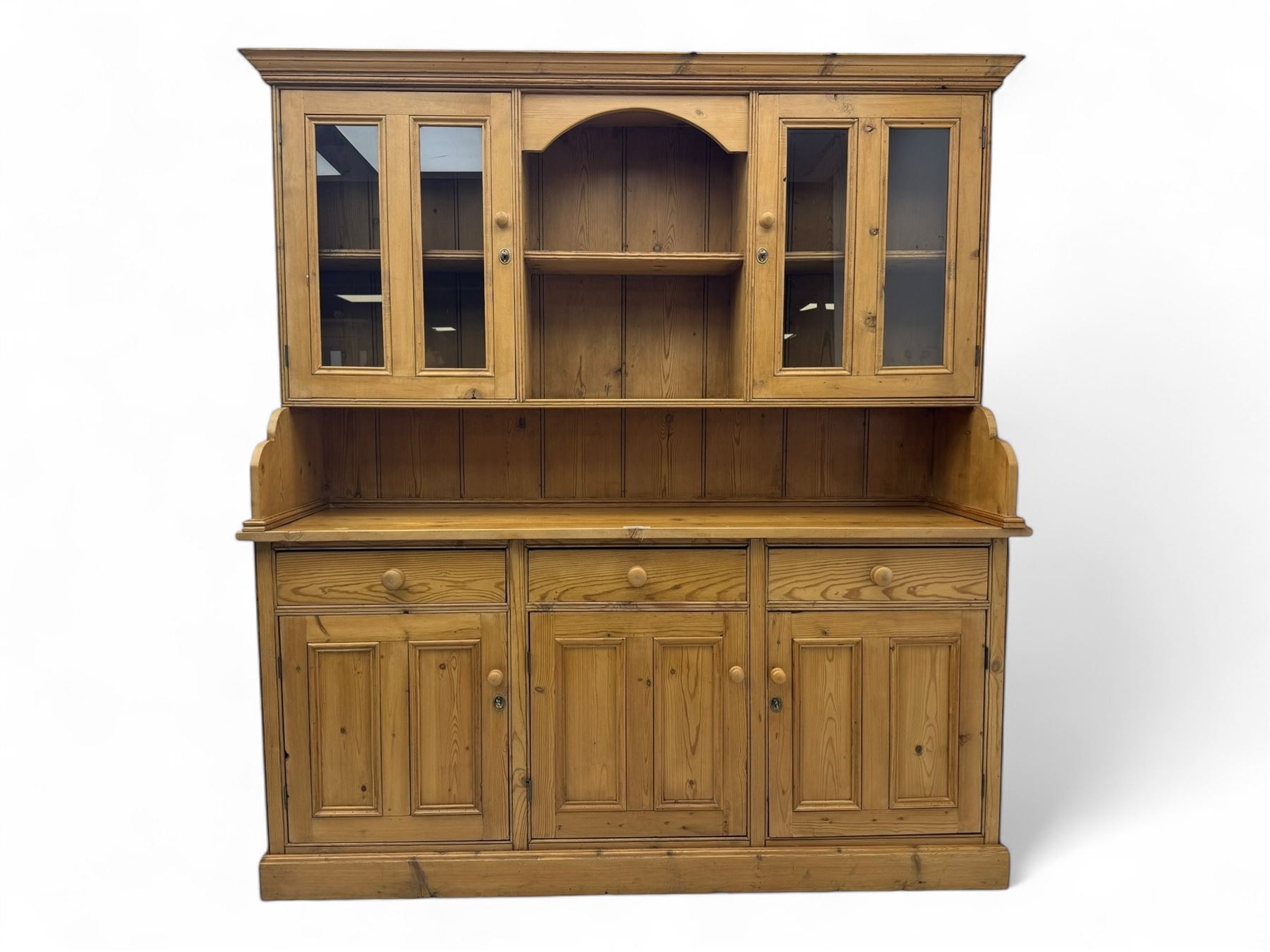 Large pine dresser, raised display cabinets over three drawers and three panelled cupboards, on plinth base