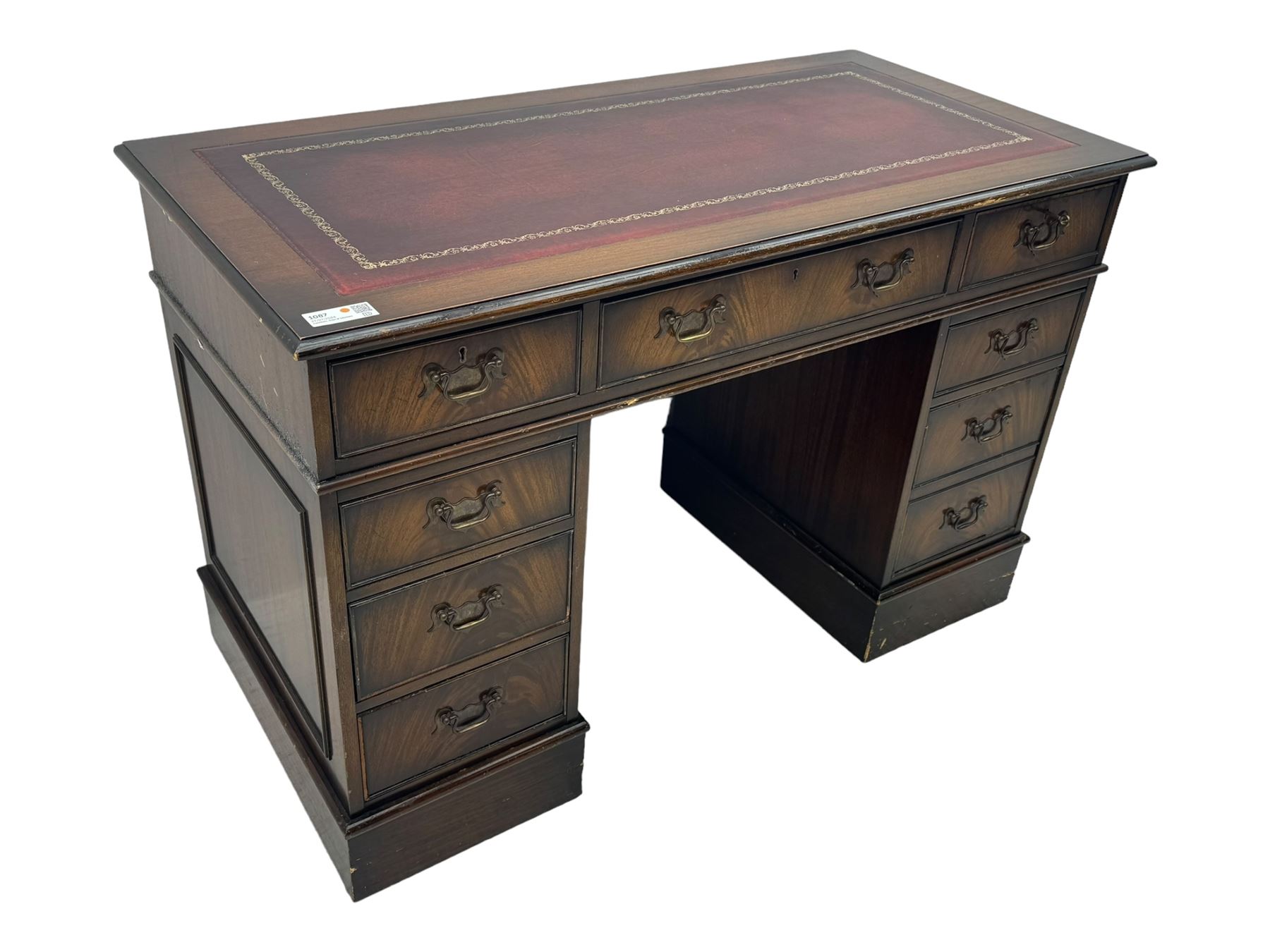 20th century mahogany twin pedestal desk, moulded rectangular top with red leather inset with gilt tooled border, central drawer over kneehole flanked by two banks of four graduating cockbeaded drawers, on plinth base