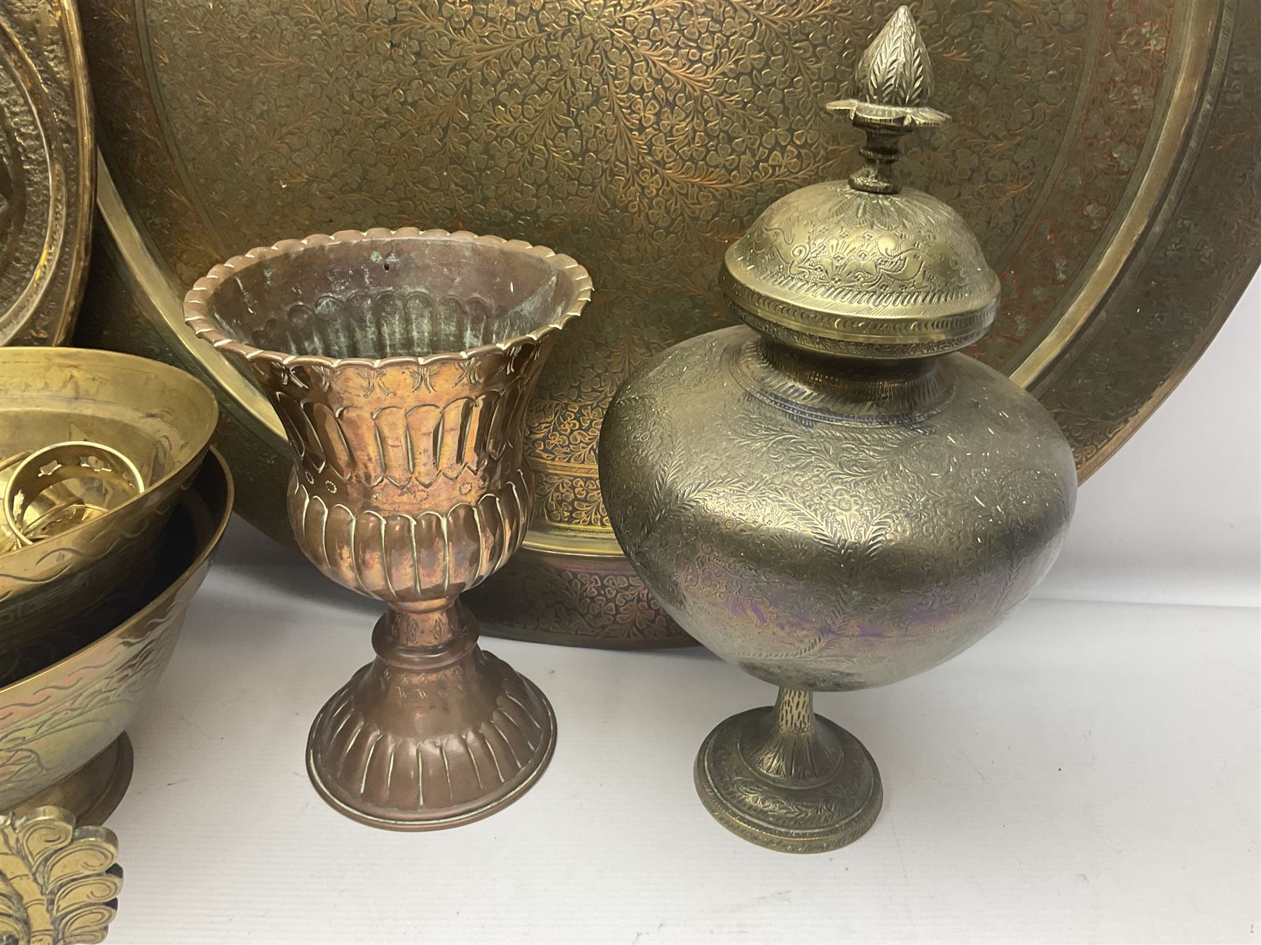 Collection of oriental brass and other metal ware, to include to large chargers, pair of covered urns, hoho bird, etc, largest charger D63cm