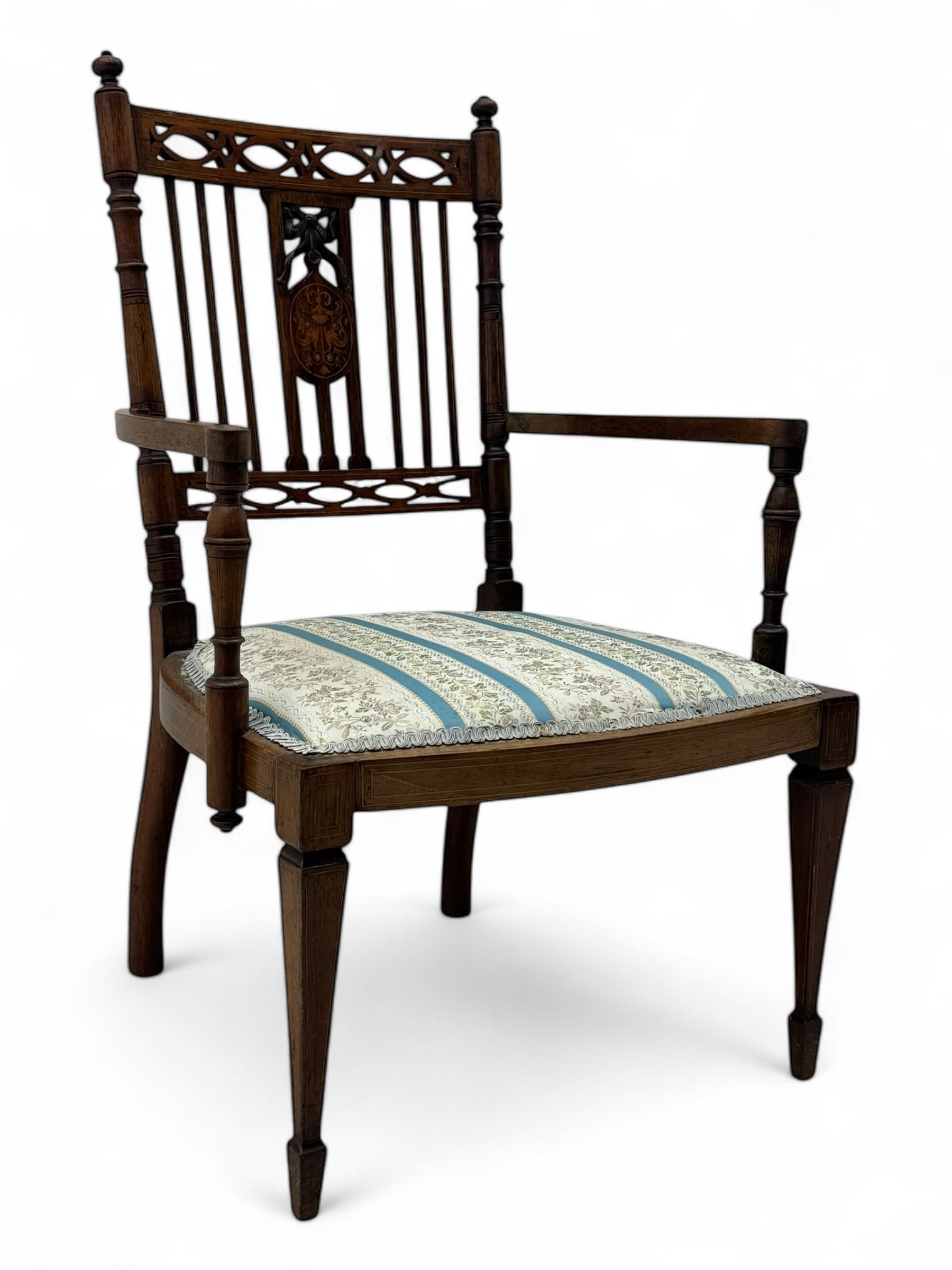 Edwardian inlaid rosewood elbow chair, pierced cresting rail over carved ribbon tie and oval inlaid panel, upholstered in stripe and floral pattern fabric, on square tapering supports with spade feet 