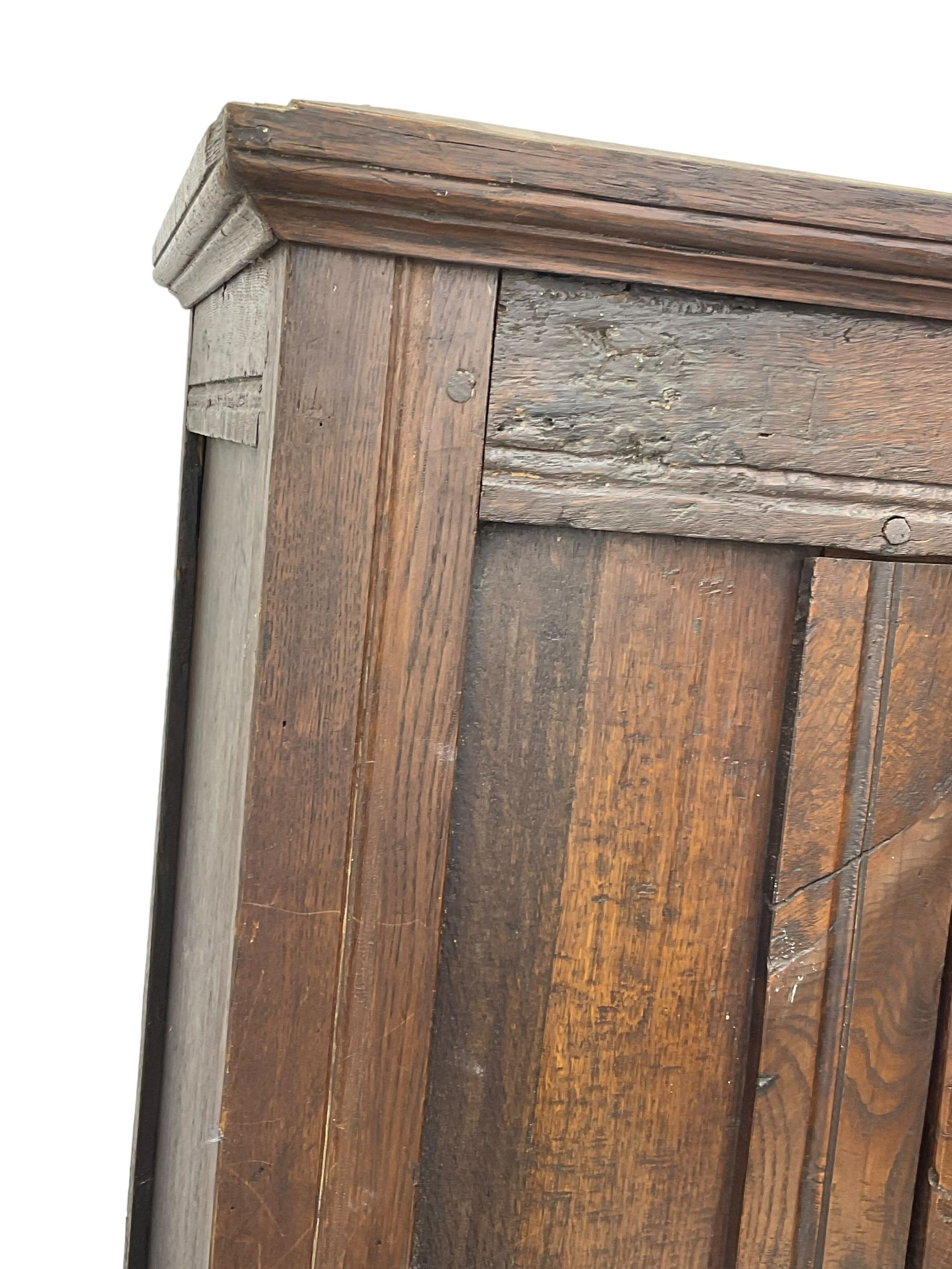 17th century and later oak hall cupboard, panelled front and sides with moulded frame, enclosed by single door with wrought metal hinges and handle, the interior fitted with hooks, on stile supports 