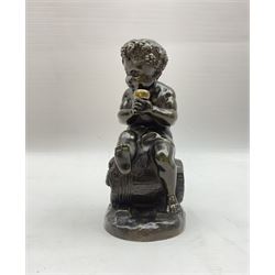 Bronzed metal model of a putti seated upon a barrel with goblet in hands, and fruiting vines adorning their head, H17.5cm