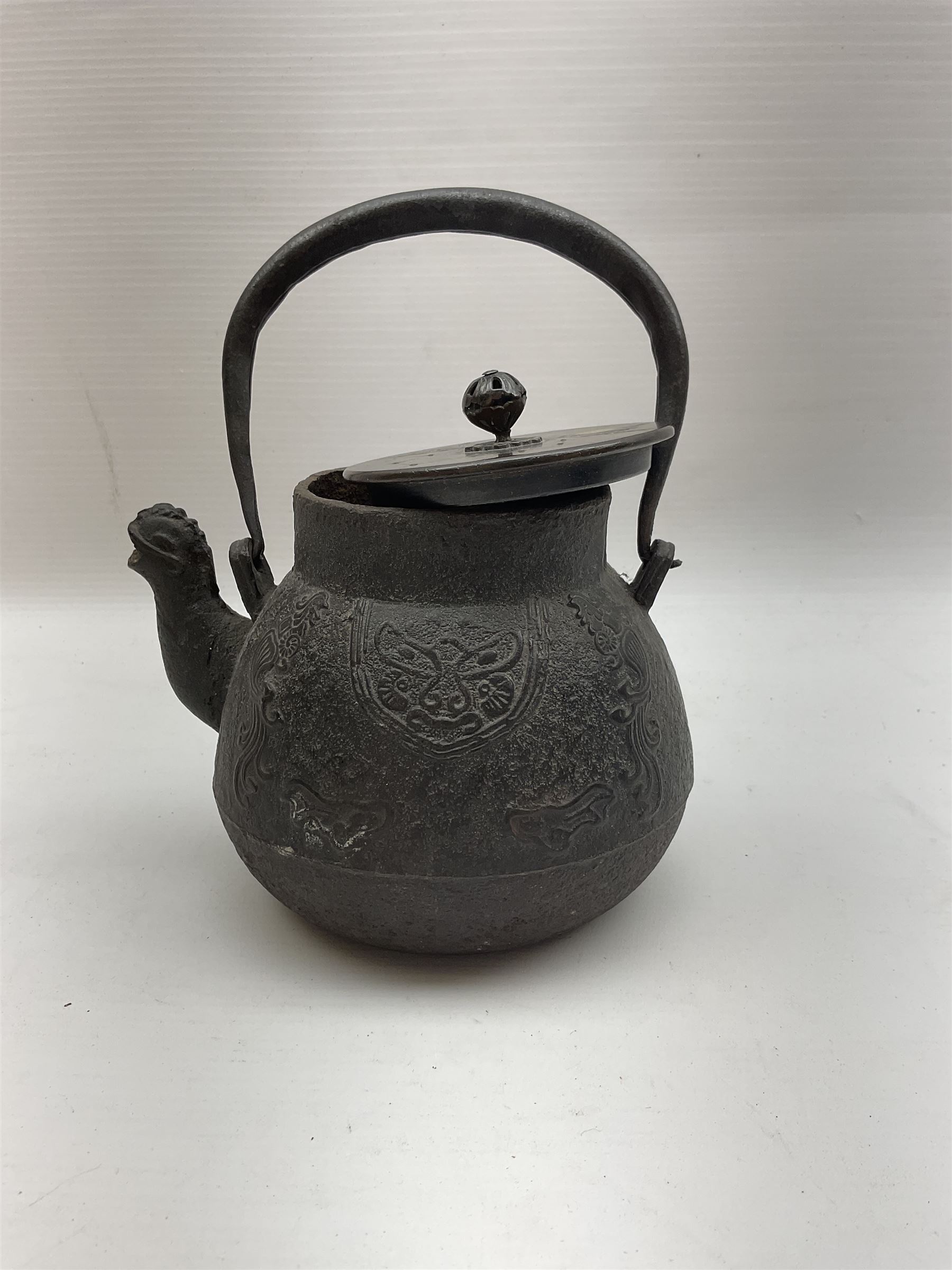 Chinese cast iron teapot, of bulbous form with ring handle, zoomorphic spout and low relief stylised decoration to body, not including handle H14cm