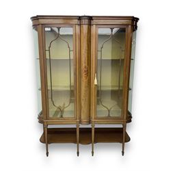 Edwardian inlaid mahogany display cabinet, projecting moulded cornice over two glazed doors, flanked by curved glazed sides and central arched panel with floral medallion, raised on square tapering supports with spade feet united by undertier