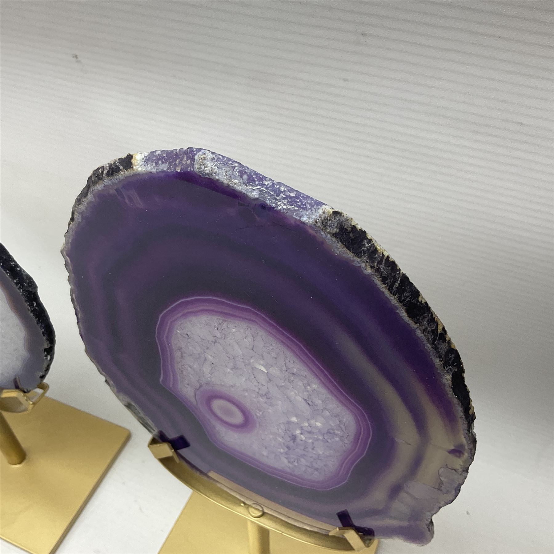 Pair of purple agate slices, polished with rough edges, raised upon gilt metal stands