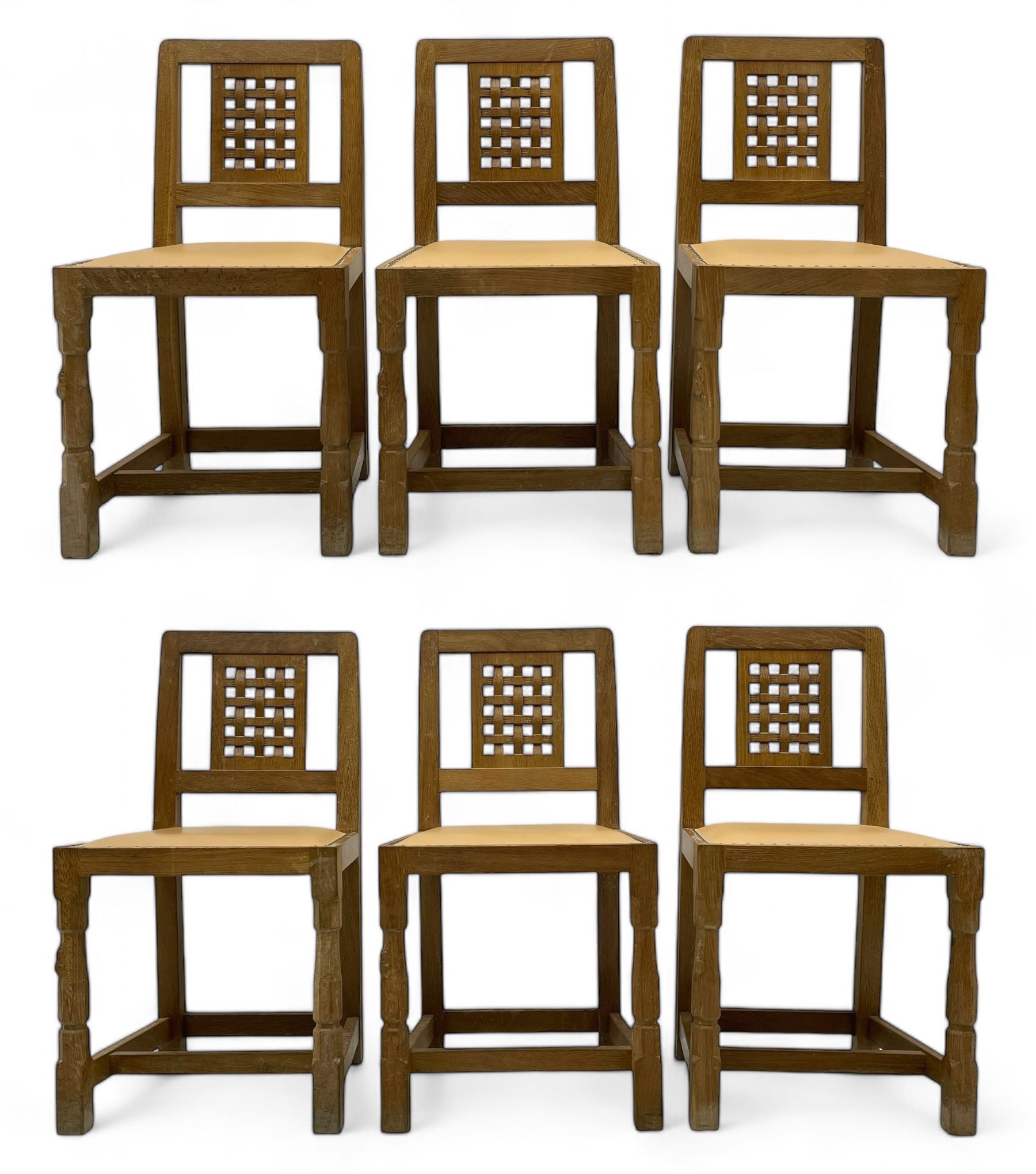 Mouseman - set of six oak dining chairs, pierced and carved lattice panel back over tan leather seat with studded band, on octagonal front supports united by plain H stretchers, carved with mouse signature, by the workshop of Robert Thompson, Kilburn 