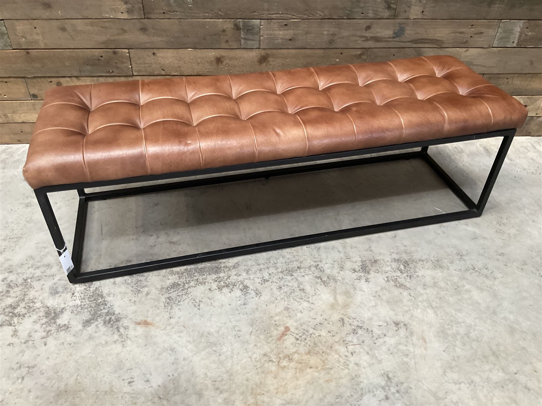 Two rectangular metal framed benches, upholstered in buttoned tan leather