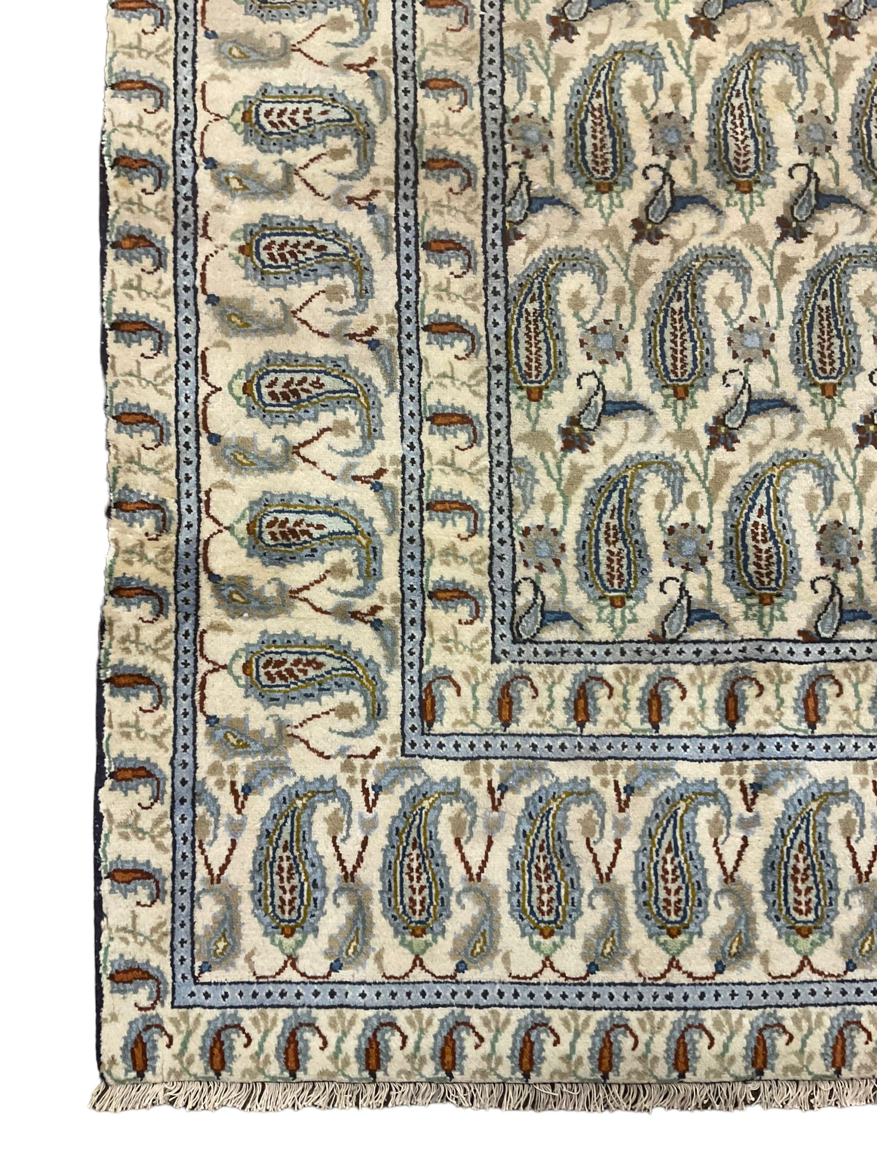 Central Persian Kashan ivory ground carpet, decorated with repeating Boteh motifs, the three band border decorated with further Boteh motifs