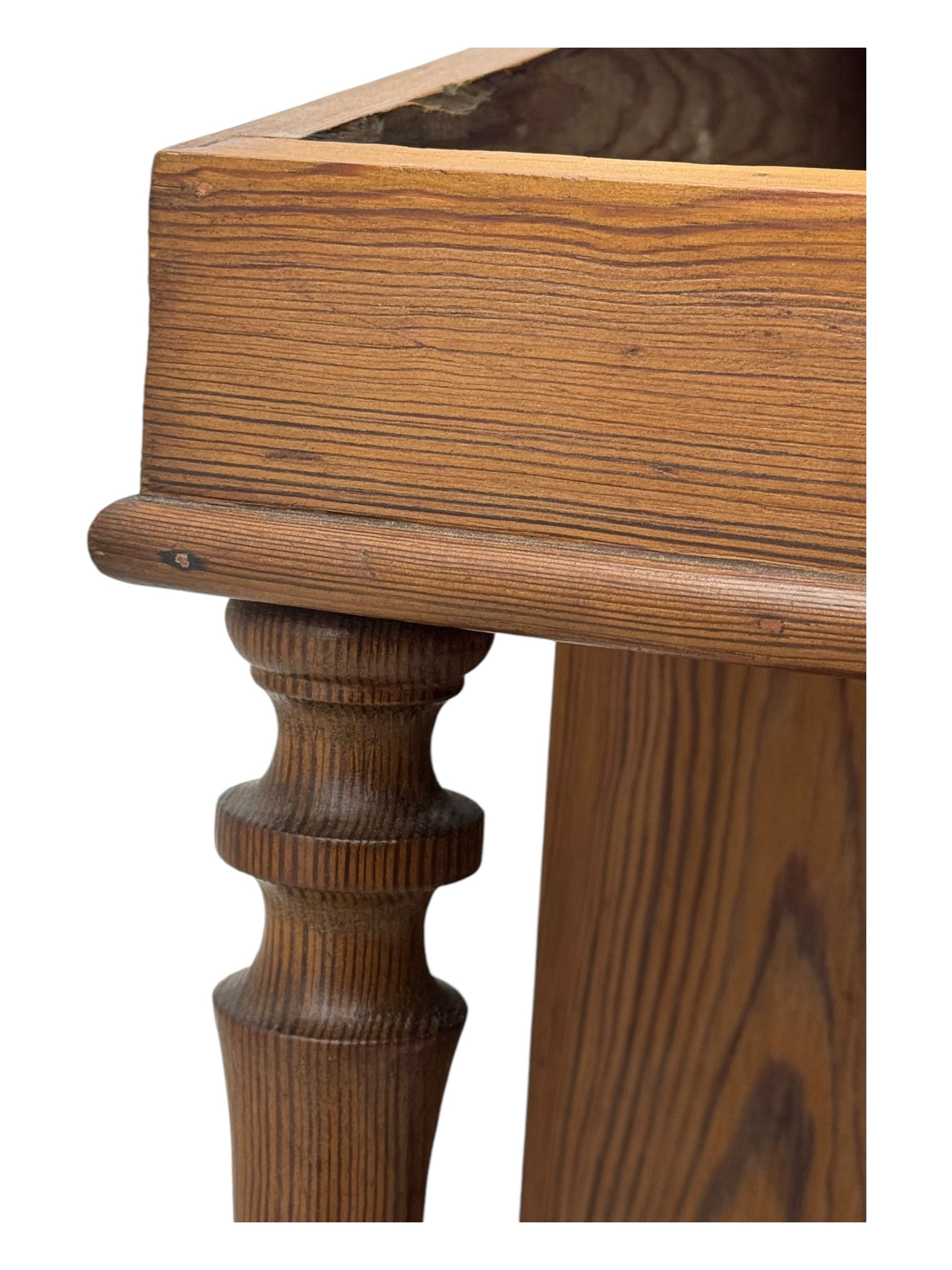 19th century pitch pine Davenport desk, sloping hinged top, fitted with four drawers, on turned column supports, turned compressed feet with castors 