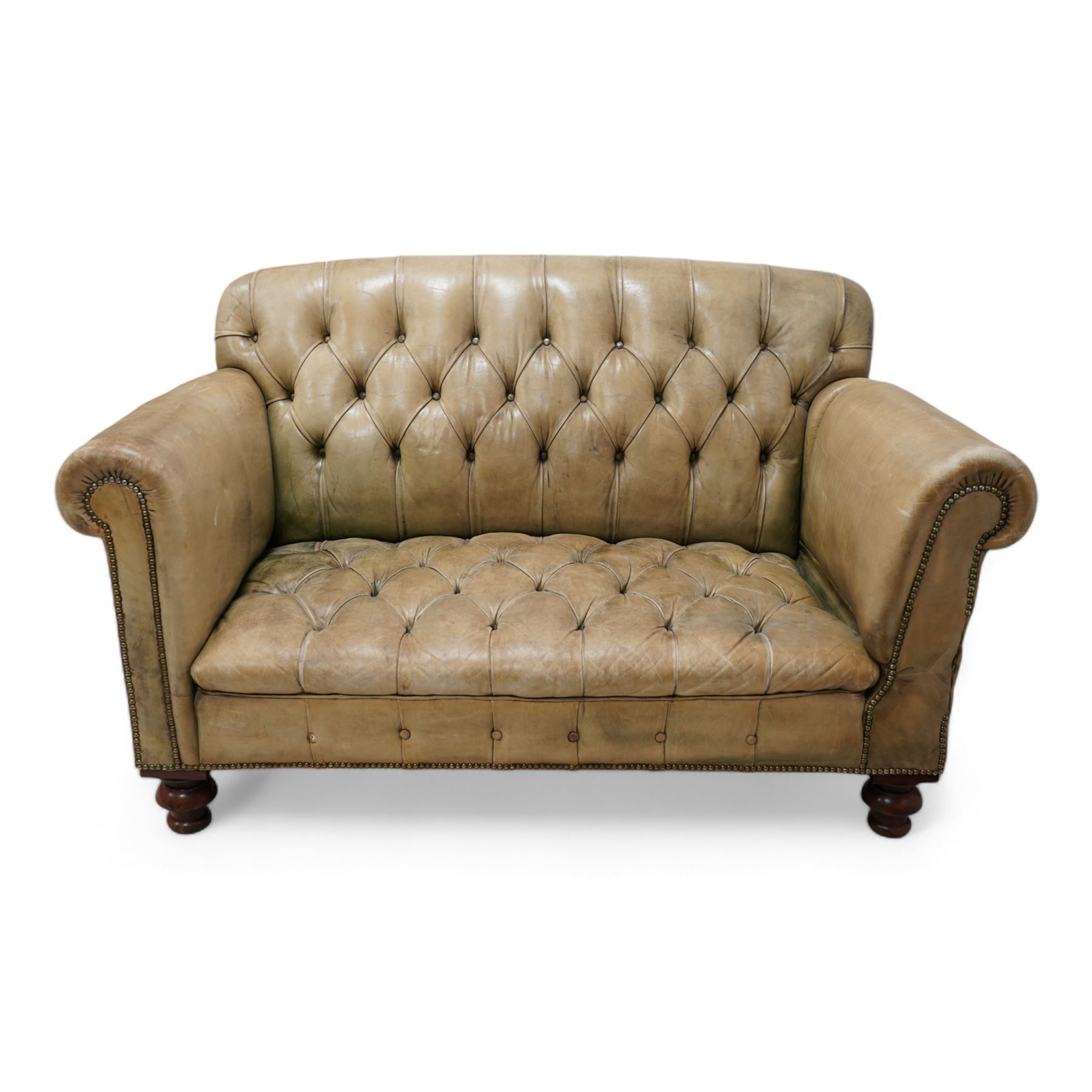 Drop-end two-seat sofa, upholstered in deeply buttoned pale green leather with stud work, on turned feet